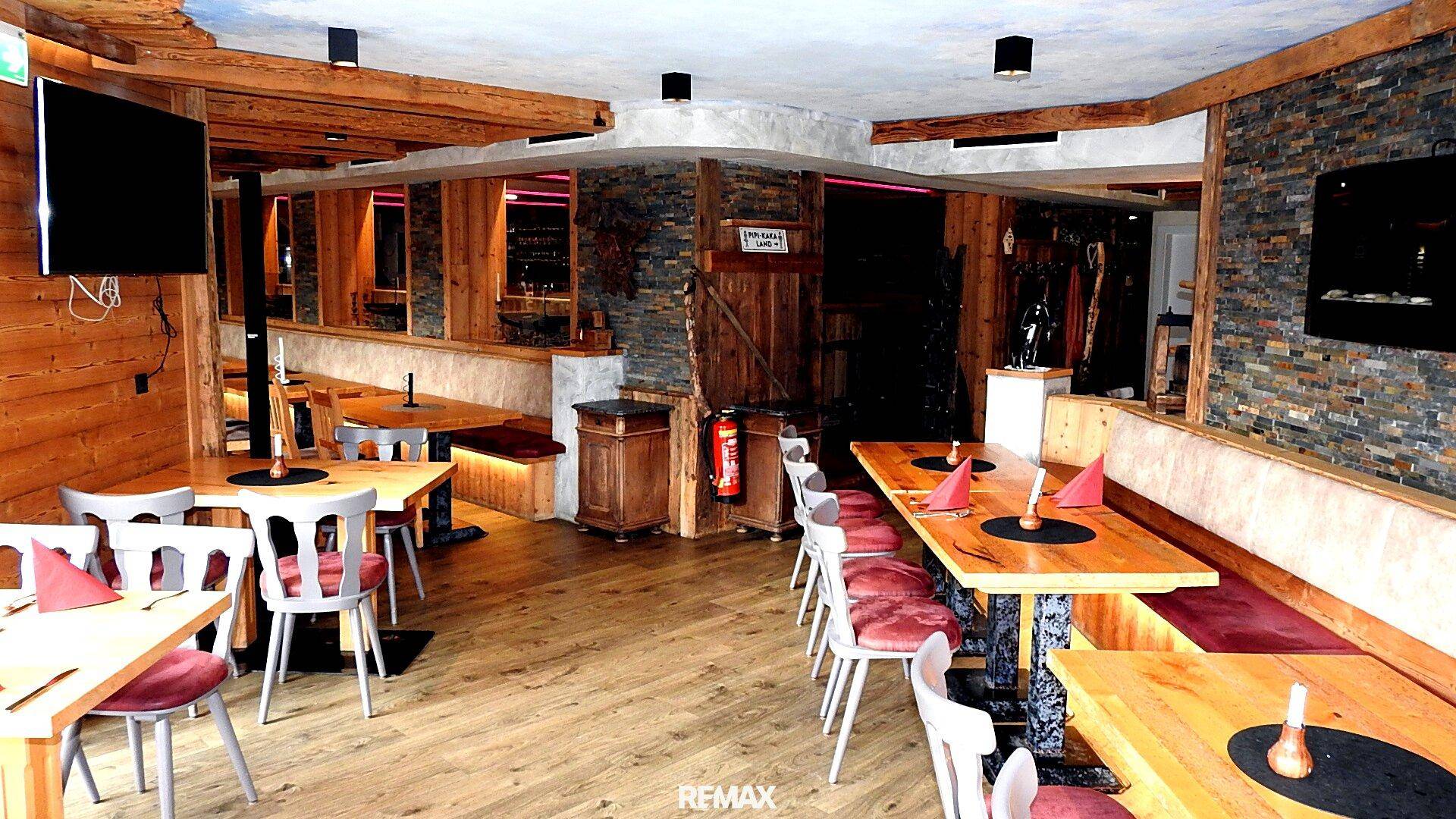 Geräumiger Restaurantbereich mit Holzböden, bequemen Sitzbänken und mehreren Tischen für Gäste.