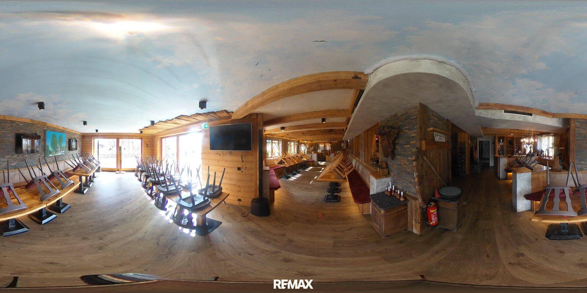 Panoramaansicht eines weitläufigen Restaurantbereichs mit Holzelementen, Tischen und Stühlen.