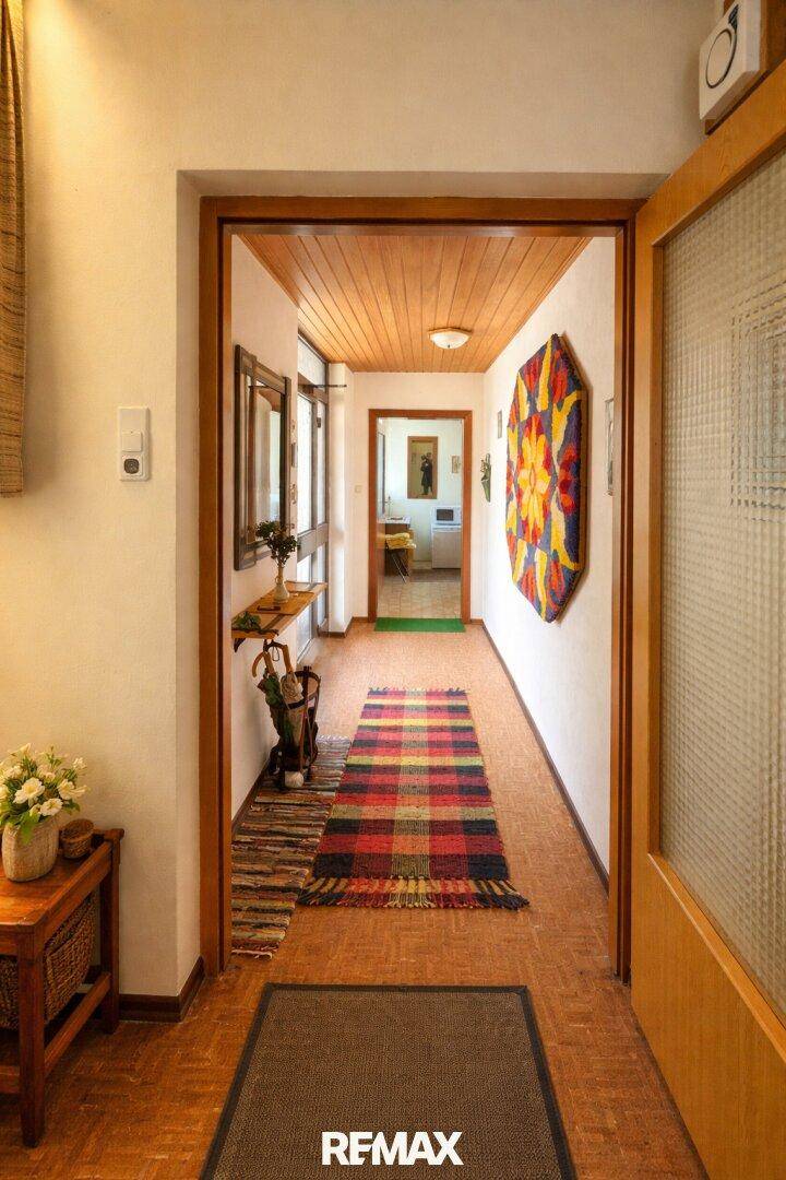 Langer Flur mit Holzdecke, gemustertem Teppich und Holzboden im traditionellen Stil.