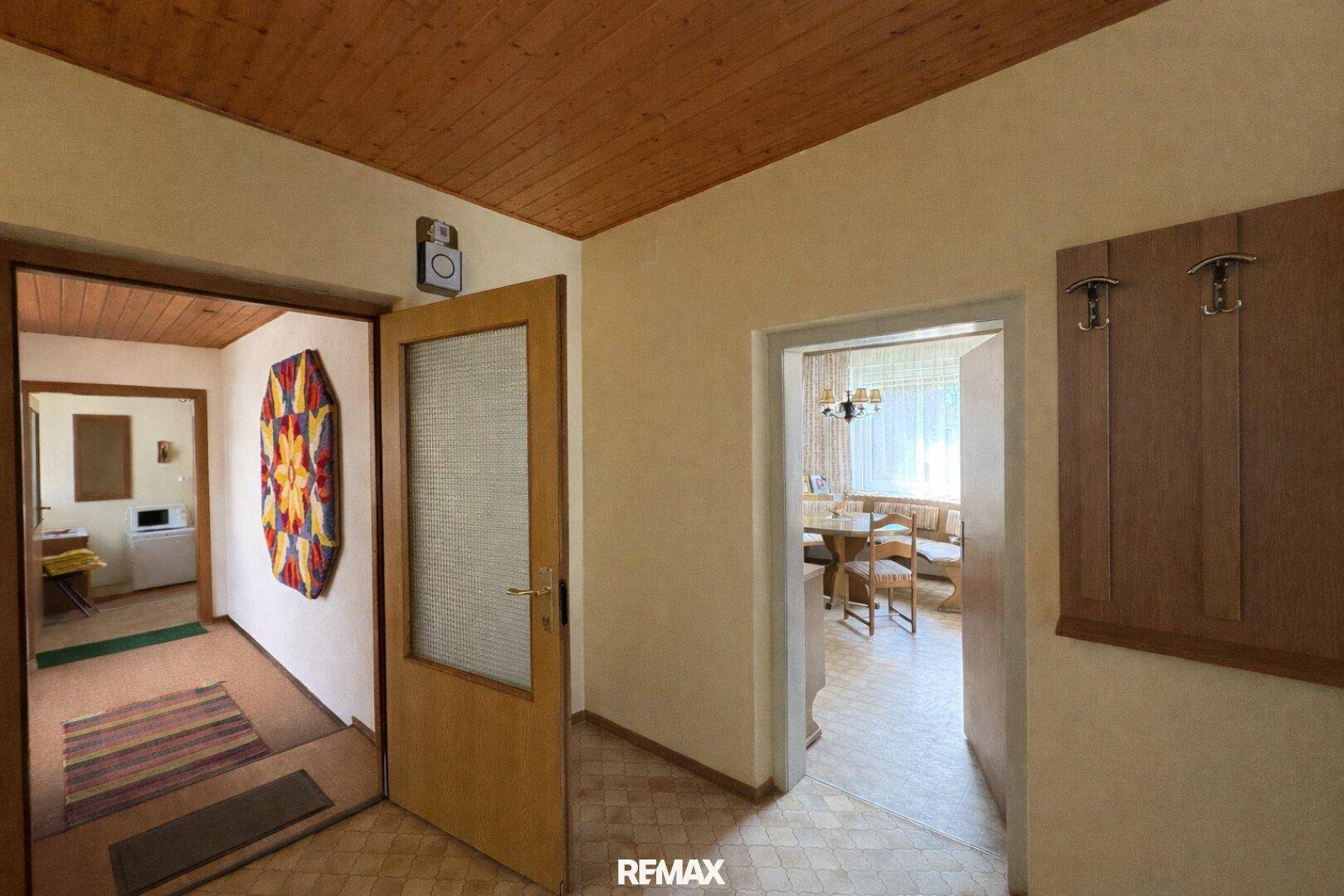 Gemütlicher Flur mit Holzdecke und Zugang zu verschiedenen Räumen, einladend gestaltet.