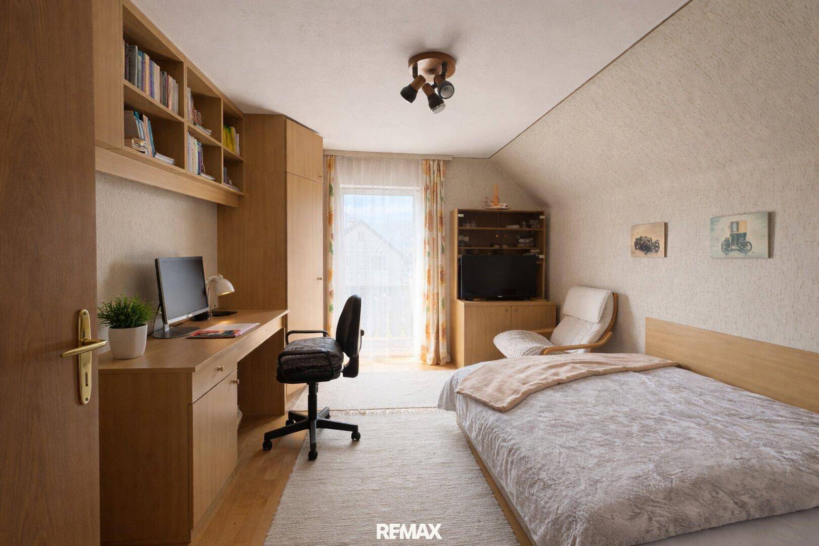 Helles Schlafzimmer im Dachgeschoss mit Schreibtisch, Bett und Bücherregal.