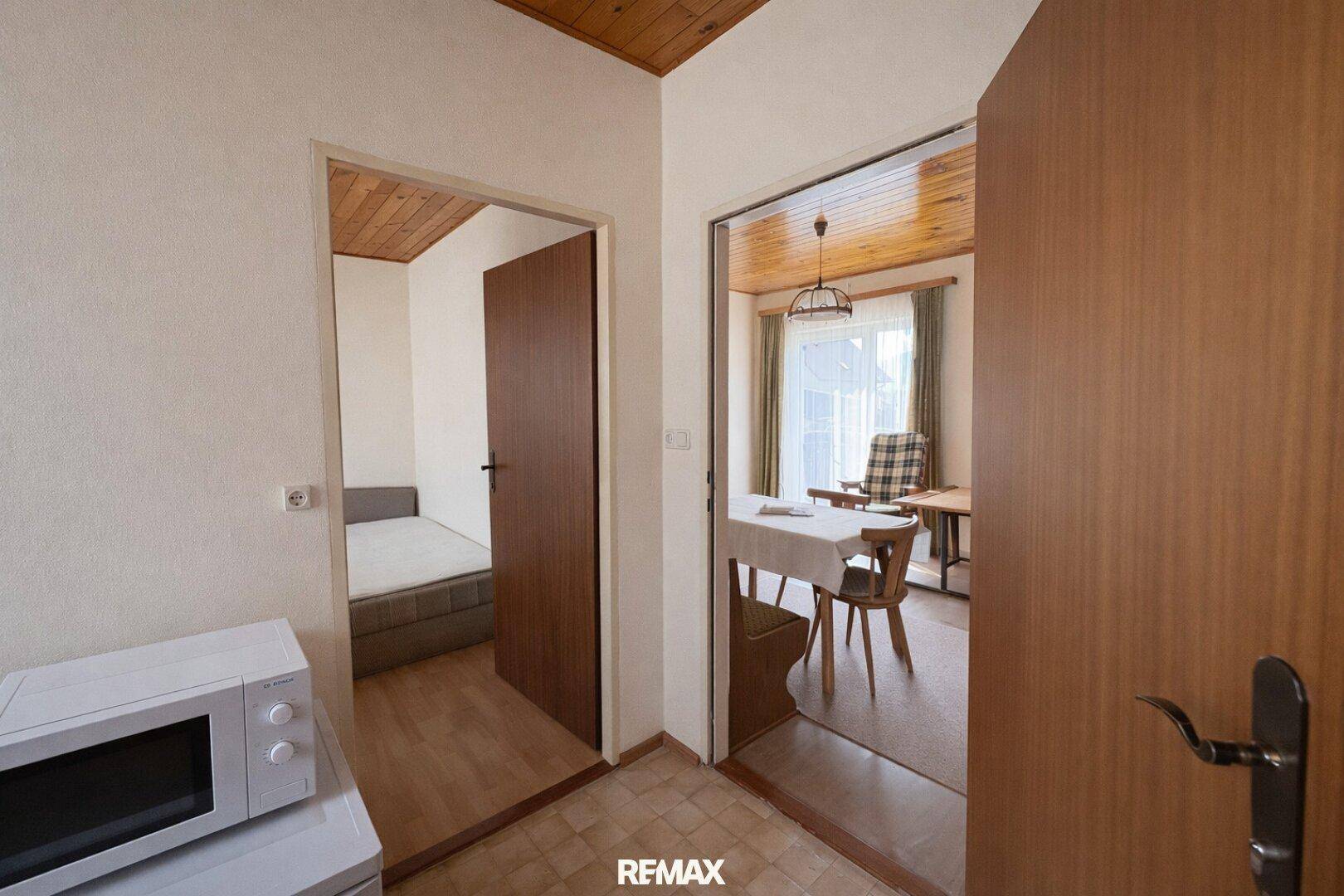 Flur mit Holzdecke und Zugang zu einem Schlafzimmer und einem Essbereich.