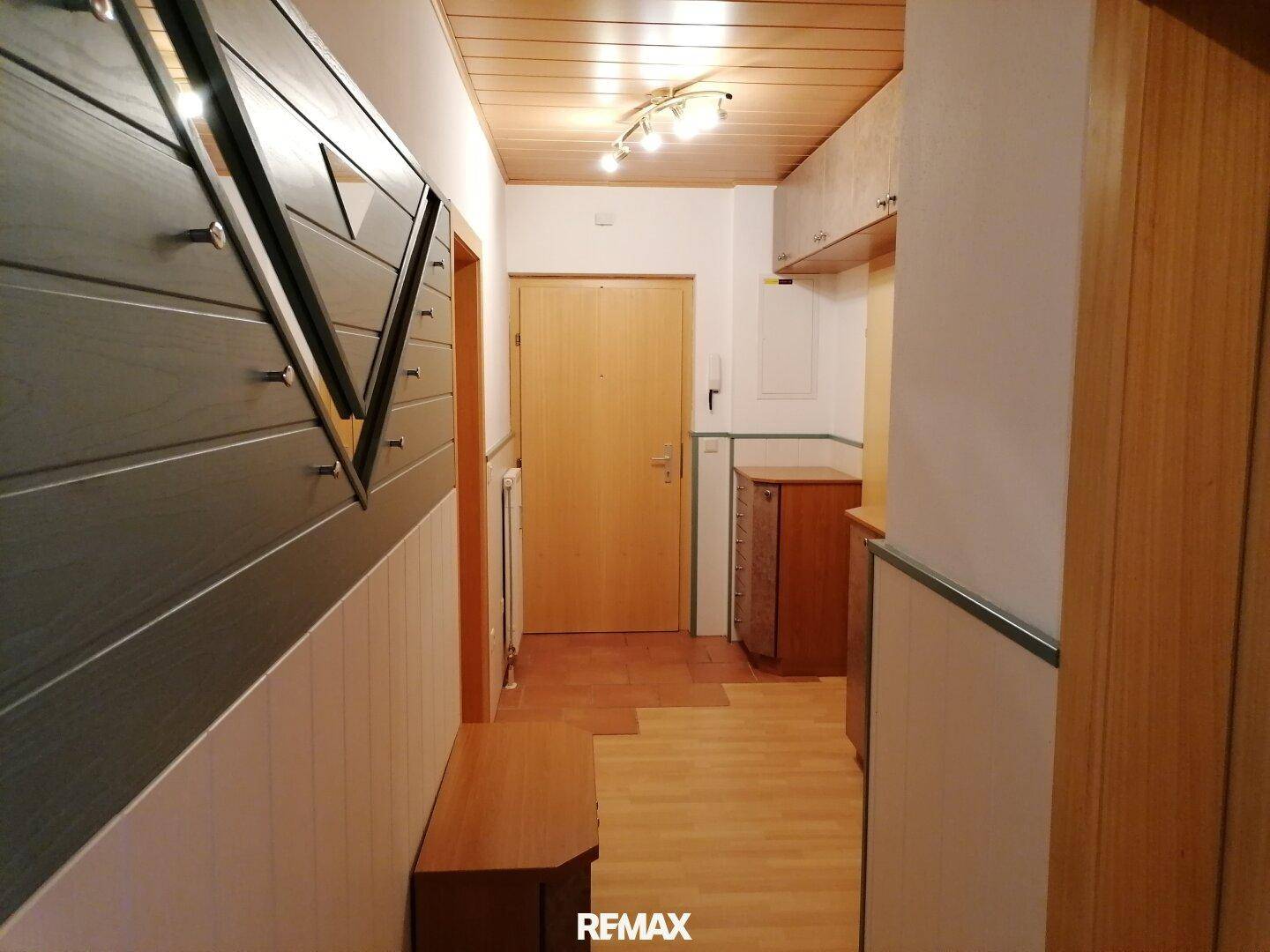 Gemütlicher Flur mit Holzdeckenverkleidung, Holzboden und einer praktischen Sitzbank.
