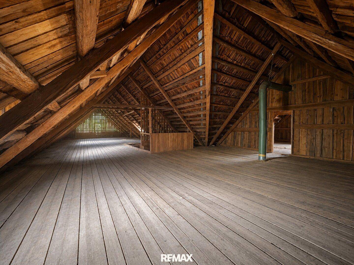 Großer, heller Dachboden mit Holzboden und sichtbaren Dachbalken, ideal für zukünftige Nutzung.