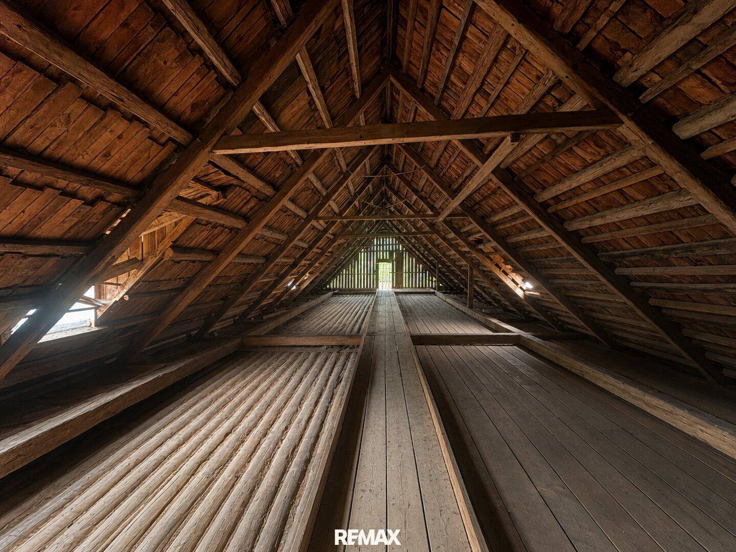 Geräumiger Dachboden mit sichtbarer Holzkonstruktion und Holzboden, bietet viel Ausbaupotenzial.