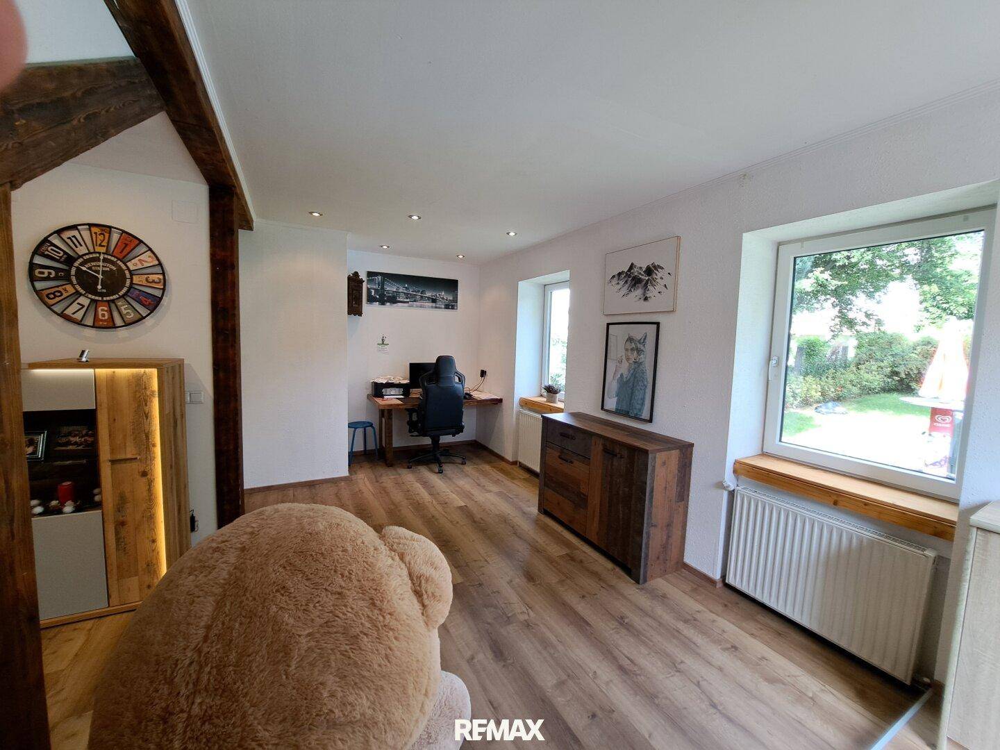 Heller Arbeitsbereich mit Schreibtisch und Stuhl, integriert in einen offenen Wohnbereich.