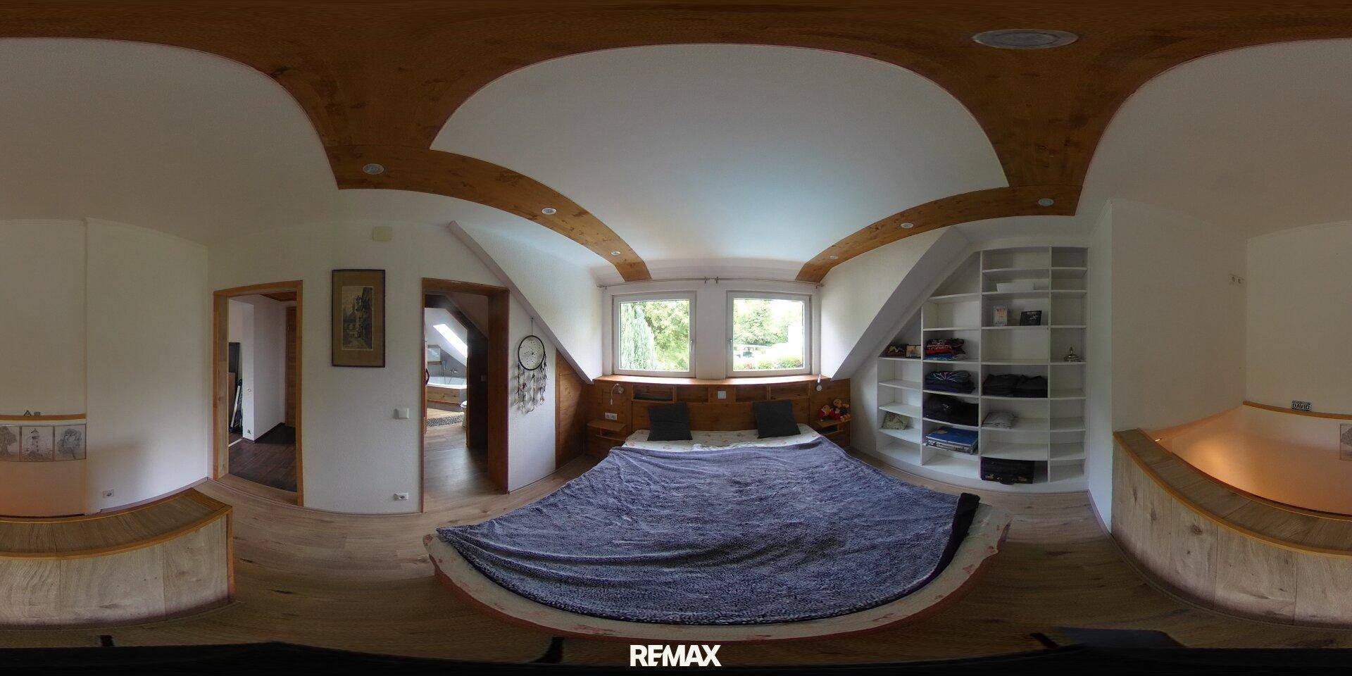 Panoramaansicht eines Schlafzimmers im Dachgeschoss mit Doppelbett und Einbauschränken.