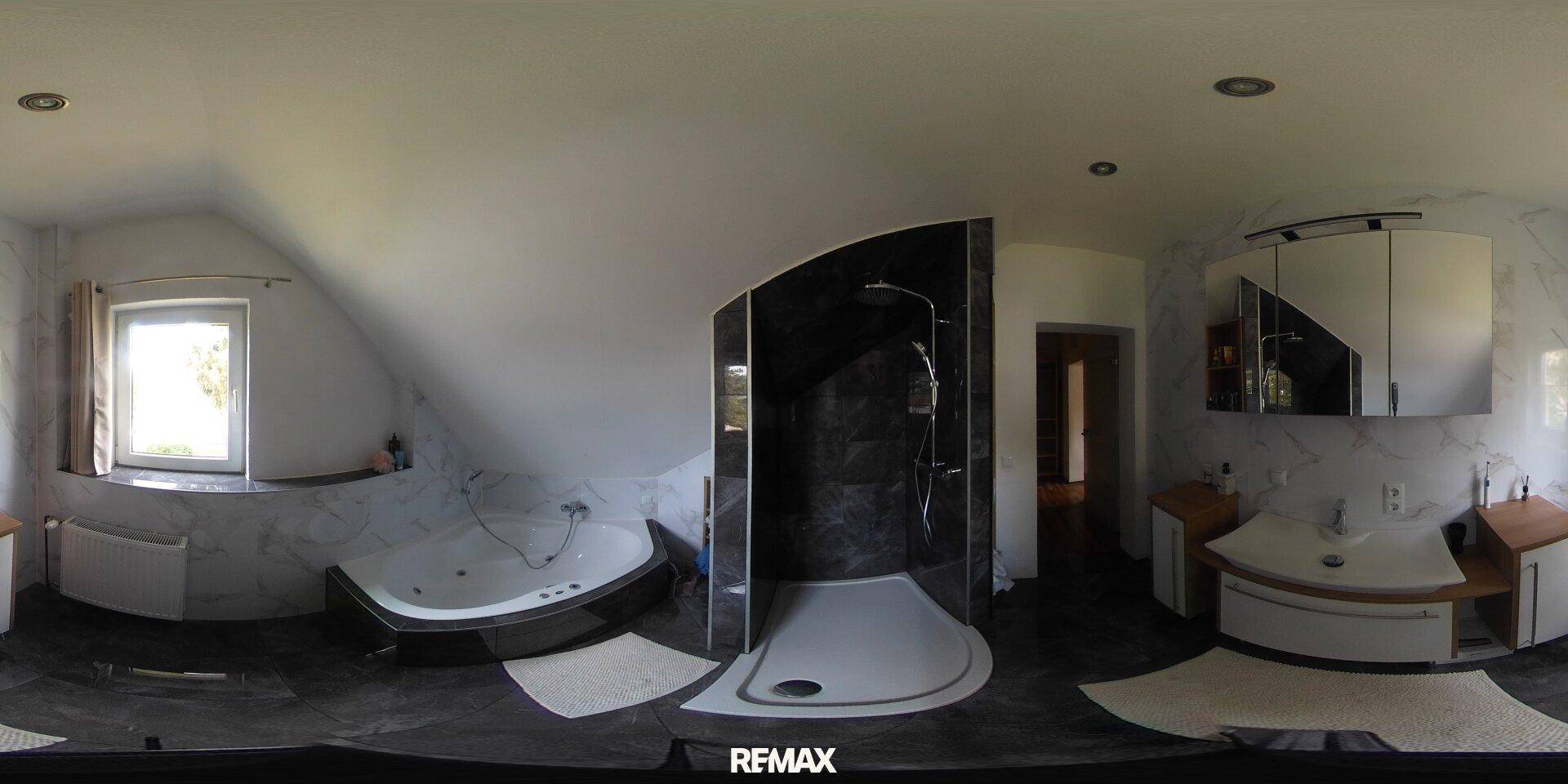 Panoramaansicht eines modernen Badezimmers mit Dusche, Badewanne und Marmorfliesen.