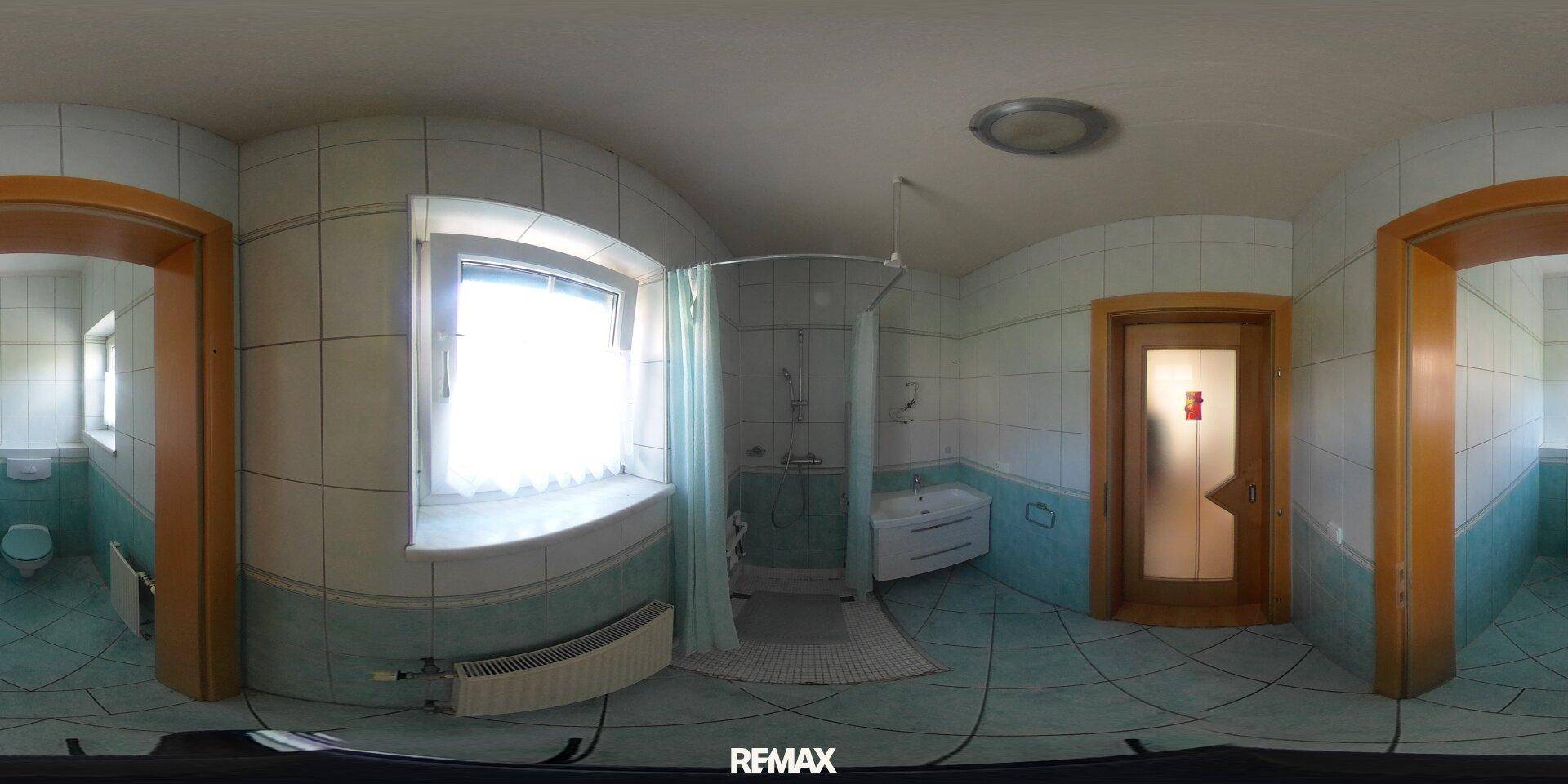 Badezimmer mit hellblauen Fliesen, Duschkabine und Fenster.