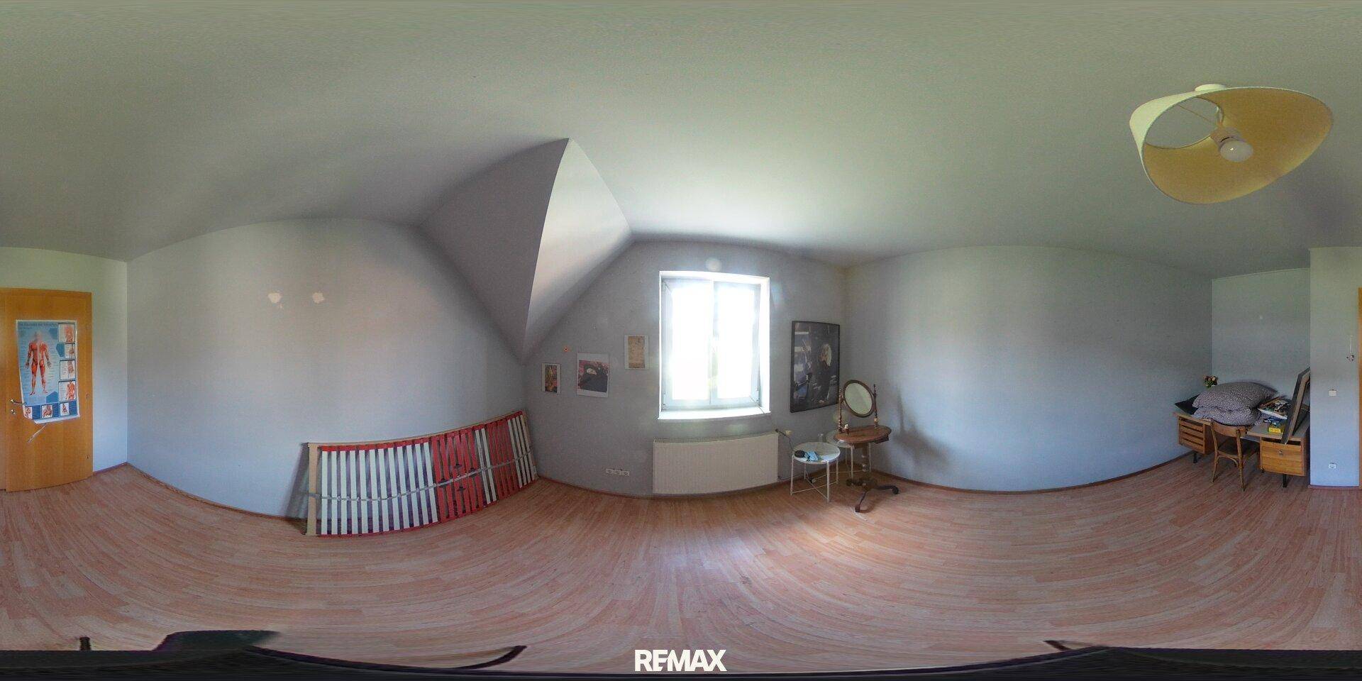 Helles Schlafzimmer im Dachgeschoss mit Laminatboden und Fenster.