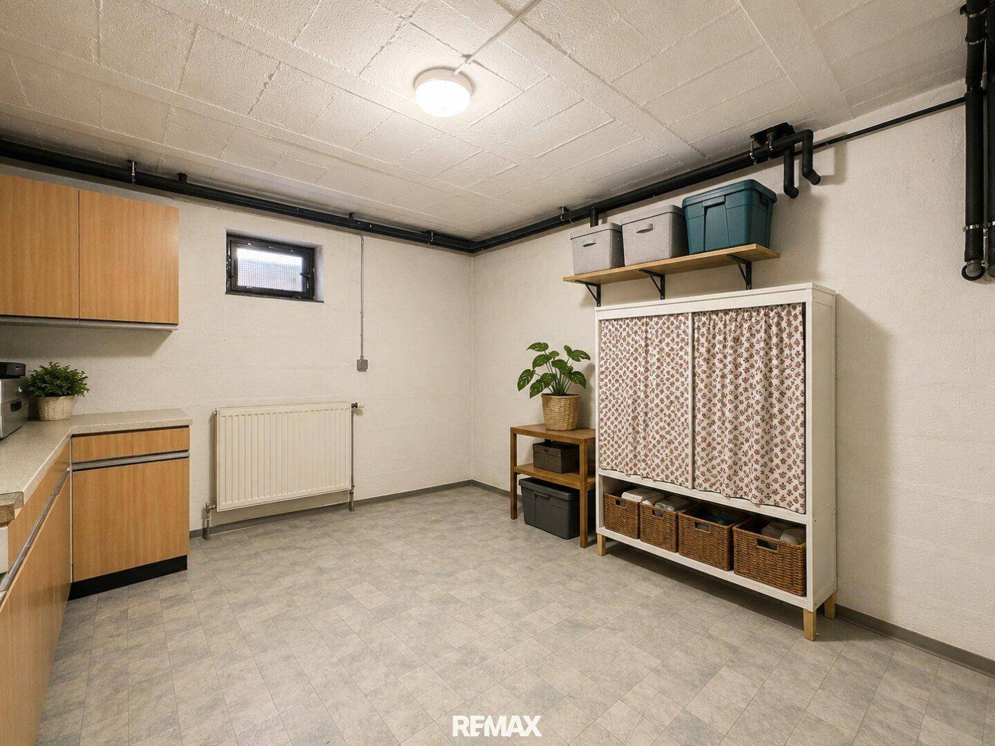 Geräumiger Kellerraum mit Arbeitsplatte, Schränken und Vinylboden.