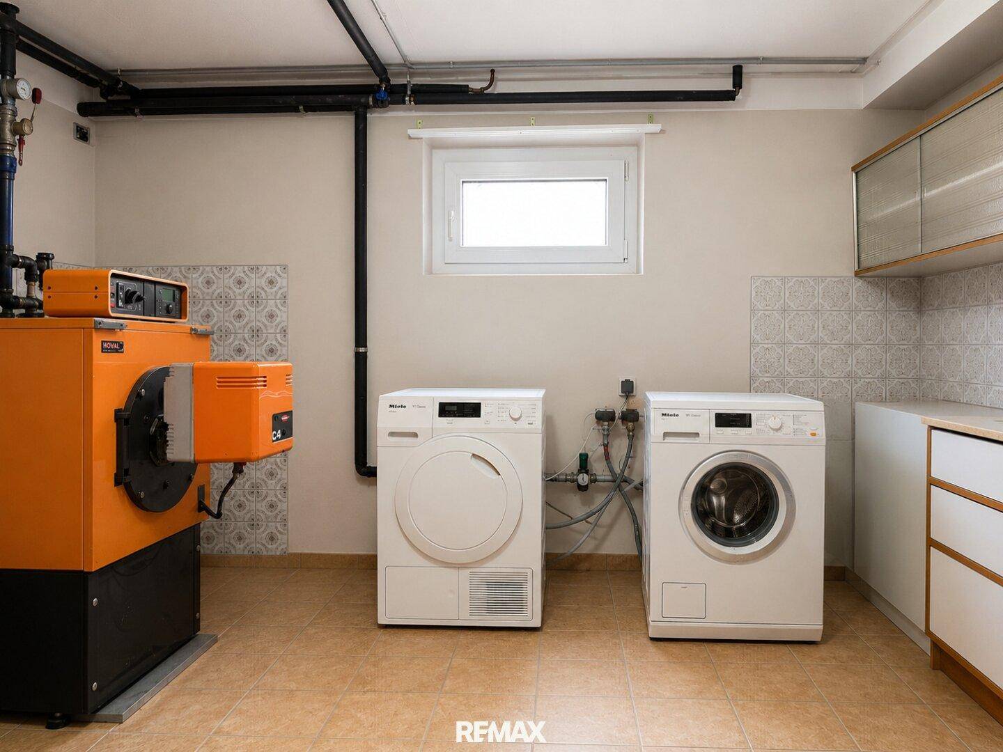 Waschküche im Keller mit Waschmaschine, Trockner und Heizungsanlage.