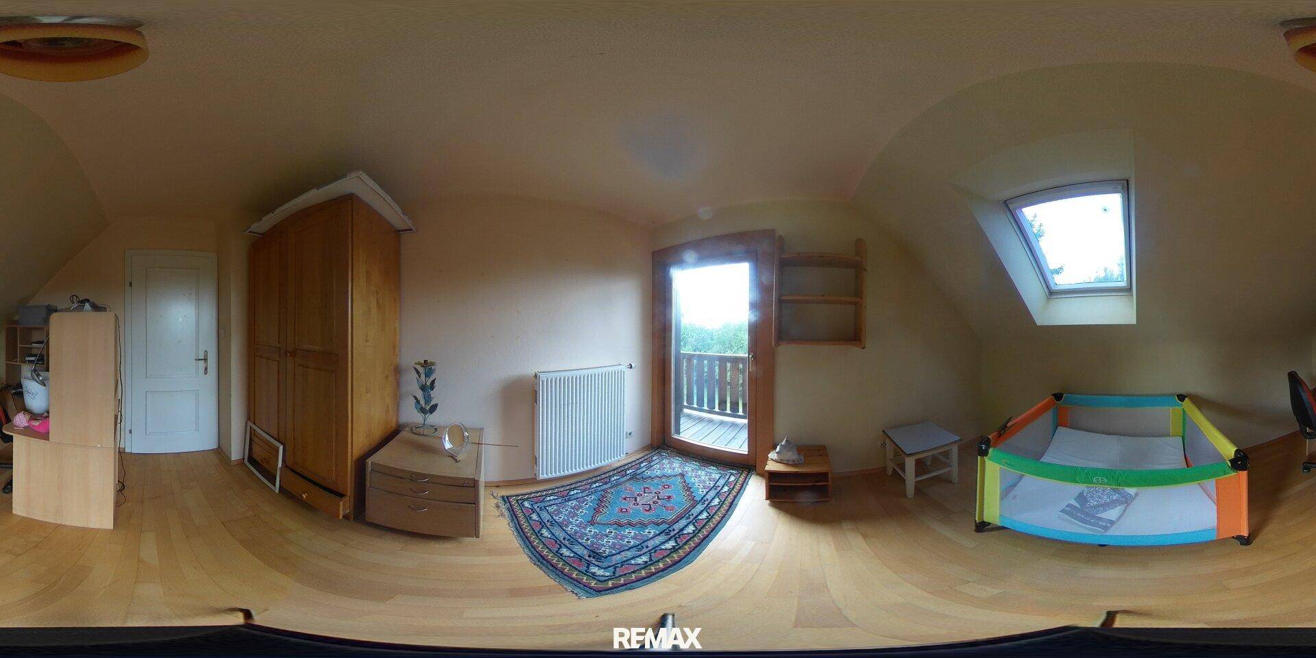 Helles Kinderzimmer mit Holzboden, Dachschräge, Babybett und Zugang zu einem kleinen Balkon.