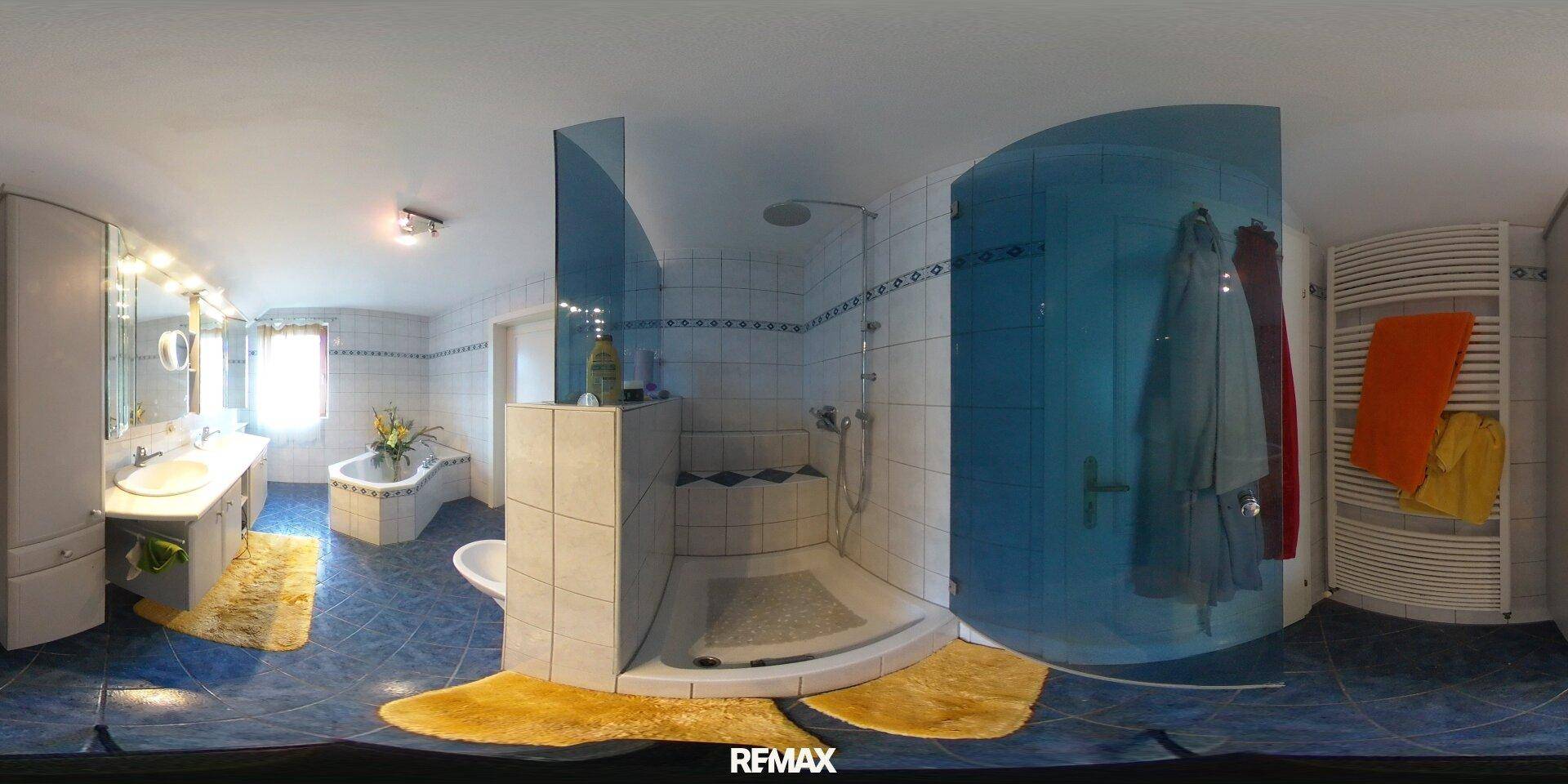 Badezimmer mit blauen Fliesen, Einzelwaschbecken, Duschkabine und beheiztem Handtuchhalter.