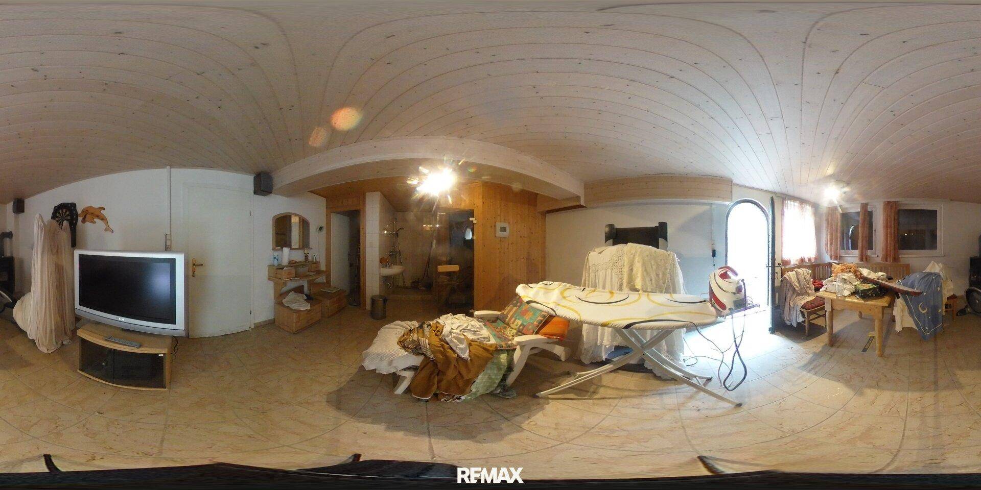 Vielseitiger Hauswirtschaftsraum mit Holzdecke, Fernseher und Stauraum für verschiedene Gegenstände.