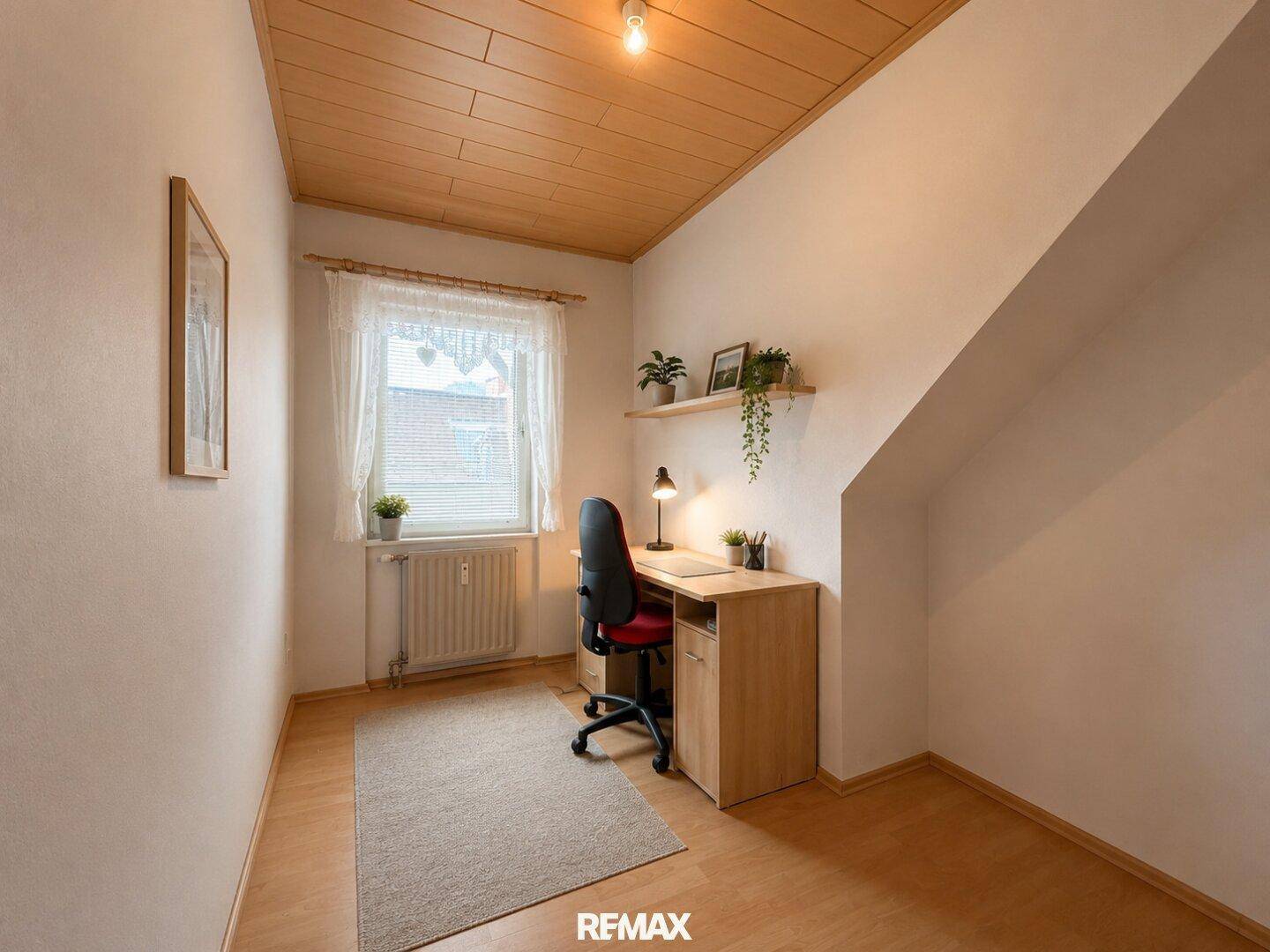Kleines Arbeitszimmer mit Schreibtisch, Stuhl und Fenster, ideal für Home-Office-Tätigkeiten.