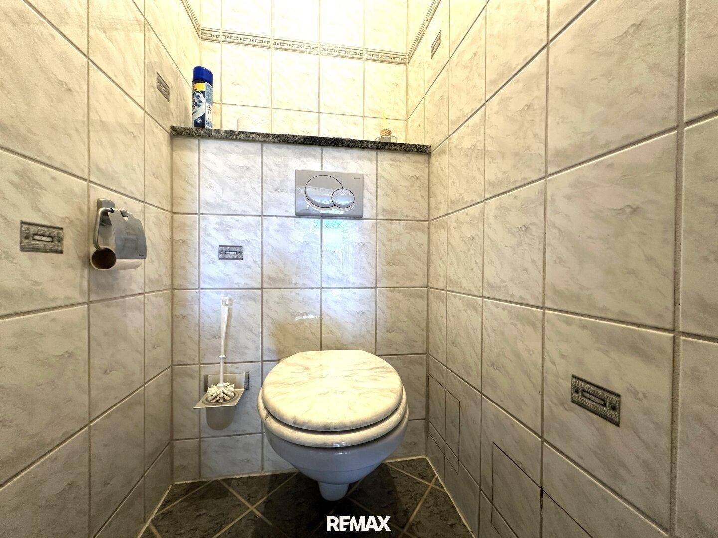 Separate Toilette, komplett gefliest, mit wandhängendem WC und einfacher Ausstattung.