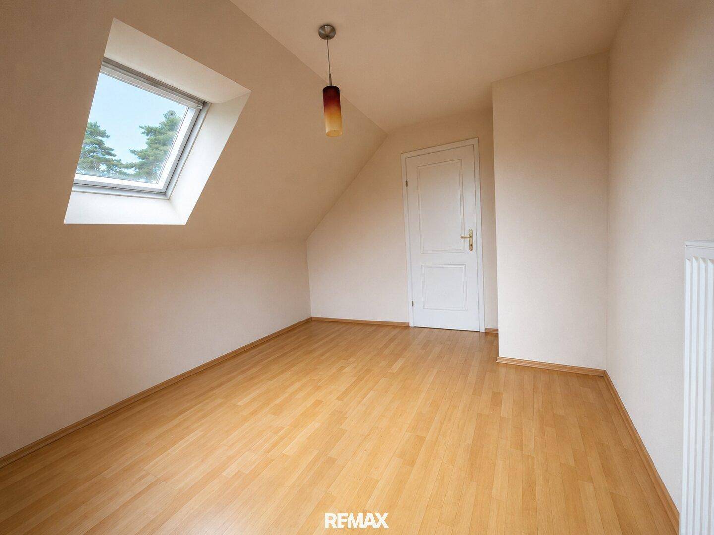 Gemütliches Schlafzimmer im Dachgeschoss mit Dachfenster und Laminatboden.
