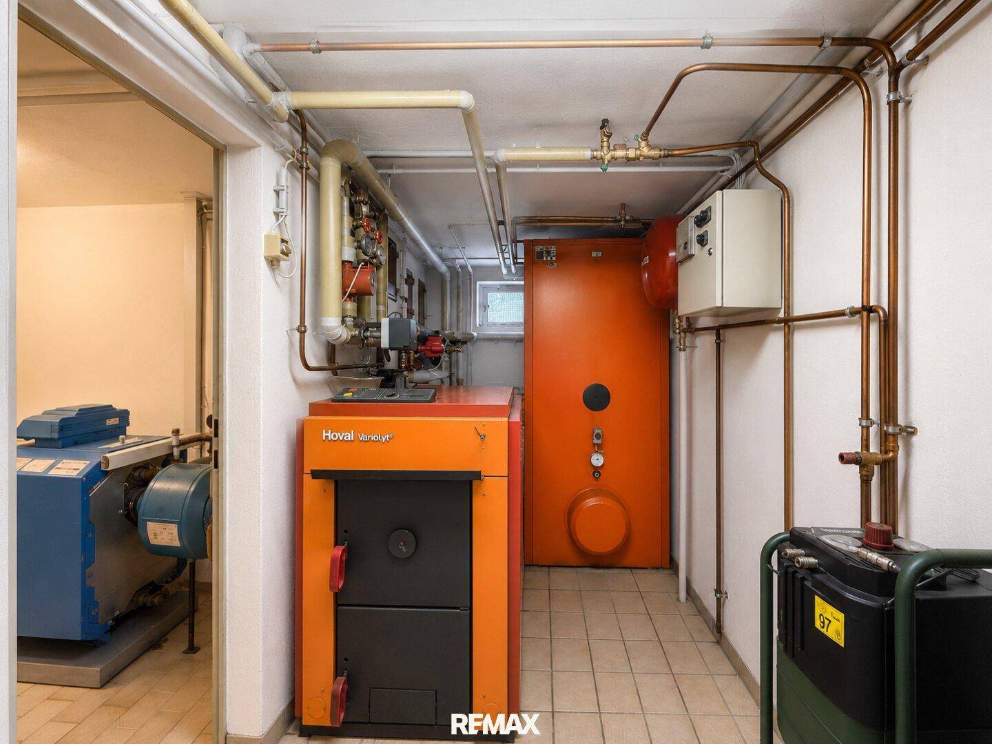 Heizungsraum im Keller mit verschiedenen Heizungsanlagen und sichtbaren Rohrleitungen.
