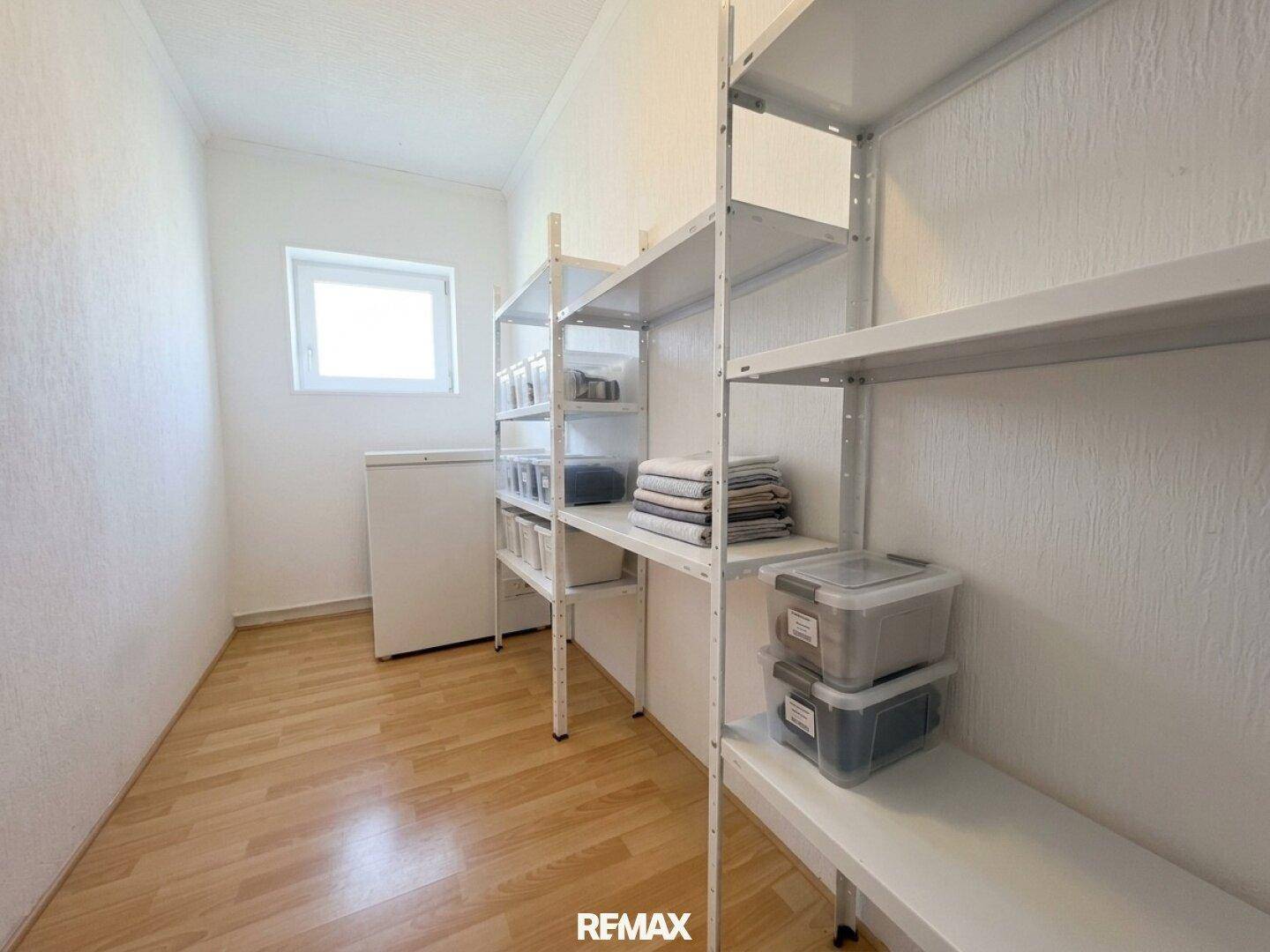 Praktischer Abstellraum mit Regalen und Gefrierschrank, bietet viel Stauraum.