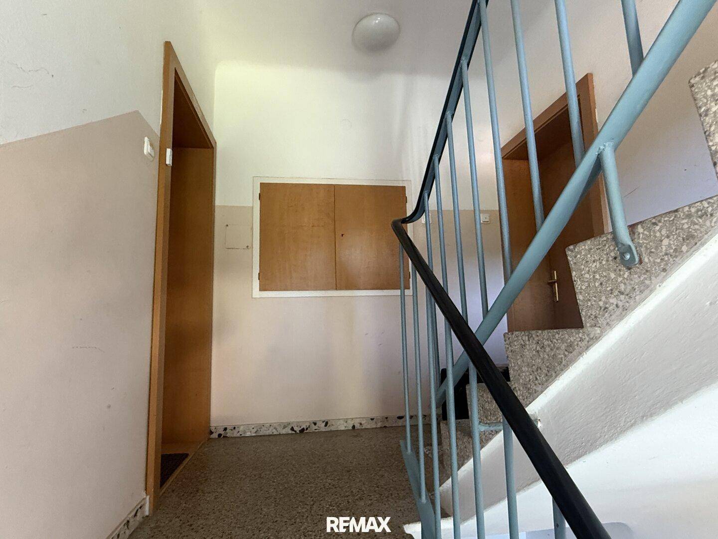 Treppenabsatz mit Zugang zu den Wohnungen und einem Schrank.