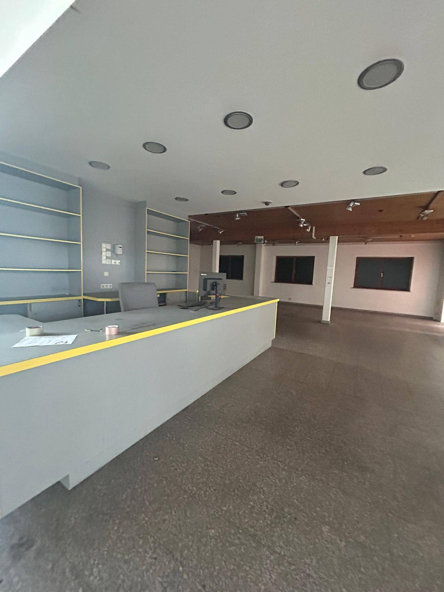 Empfangsbereich mit Theke, Regalen und Einbaustrahlern, modern und funktional gestaltet.
