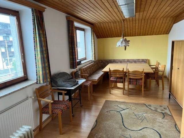 Gemütlicher Essbereich mit Holztisch, Eckbank und Holzdecke, ideal für Pausen.