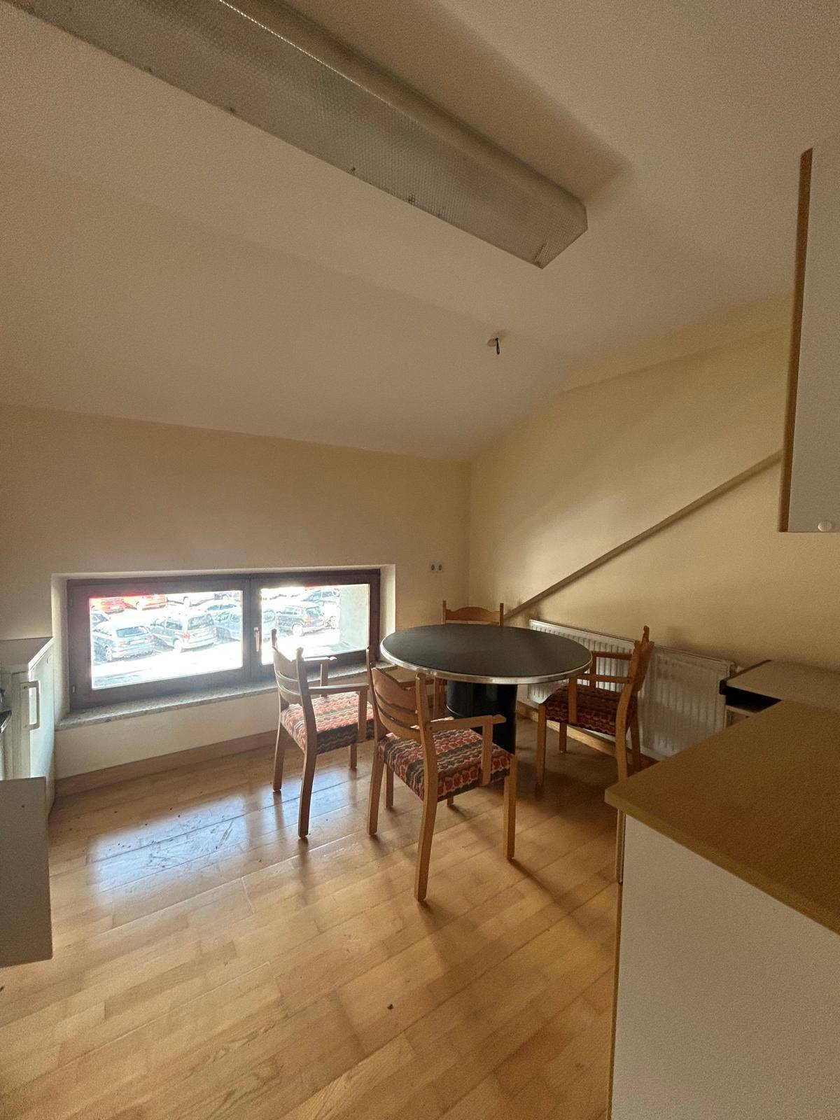 Kleine Küche mit Essbereich, Holzboden und Fenster, ideal für Mitarbeiterpausen.