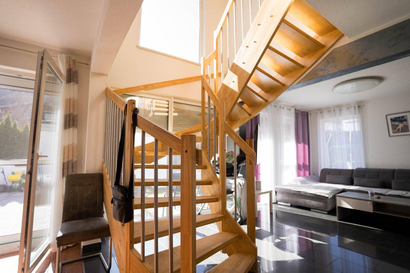 Elegante Holzwendeltreppe im Wohnbereich, die die verschiedenen Ebenen verbindet.