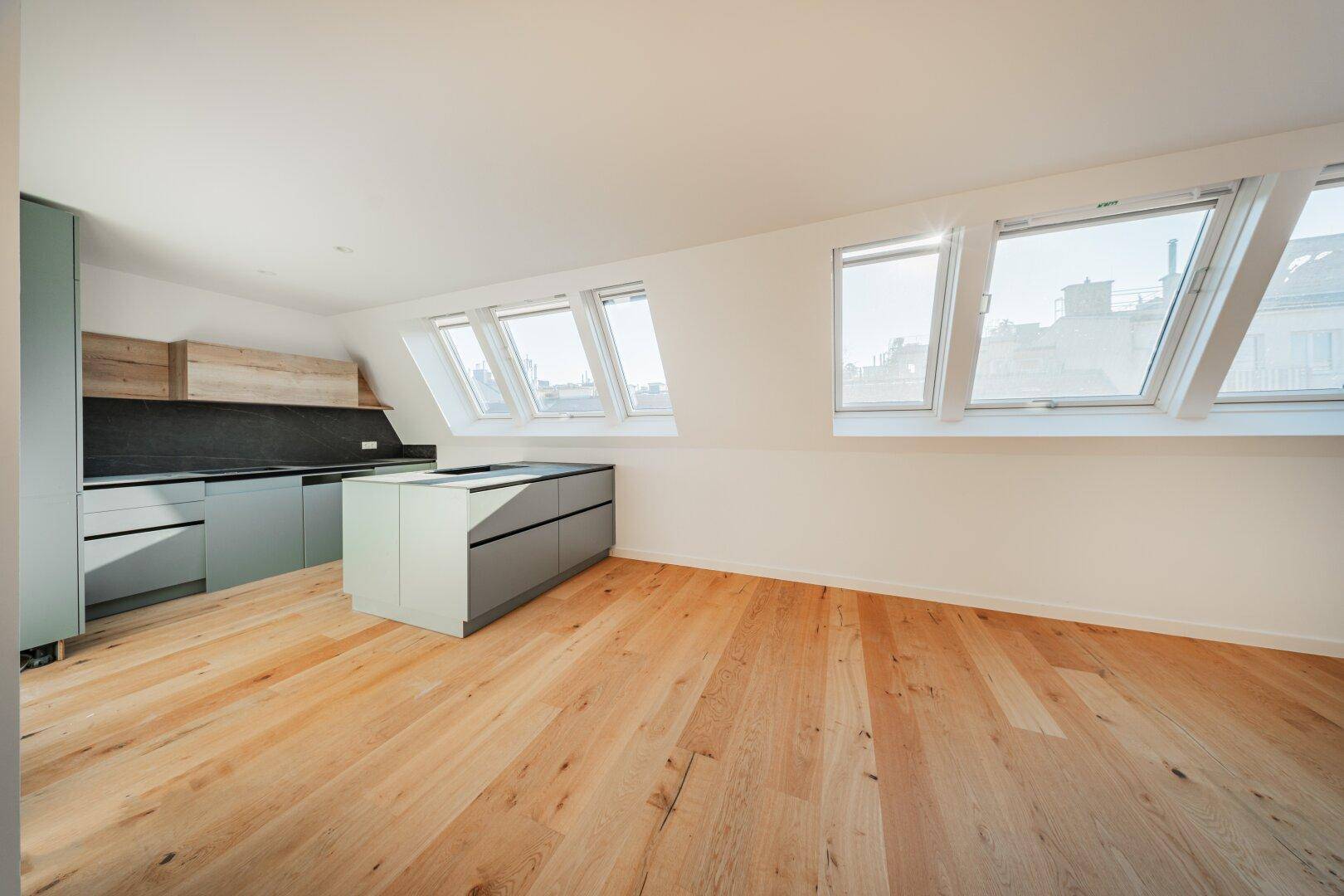 Moderne Einbauküche mit grauen Schränken, Holzdetails und einer praktischen Kücheninsel.