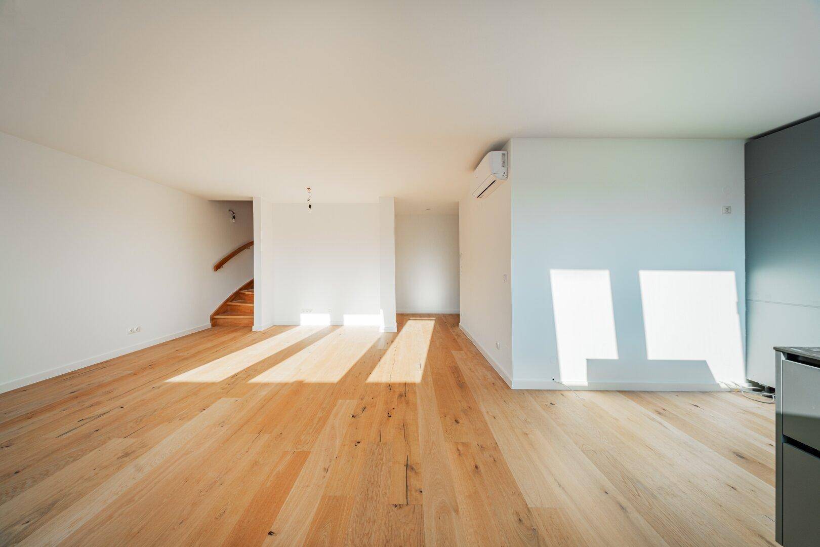 Lichtdurchfluteter Wohnbereich mit Holzboden, Klimaanlage und viel Platz für individuelle Gestaltung.