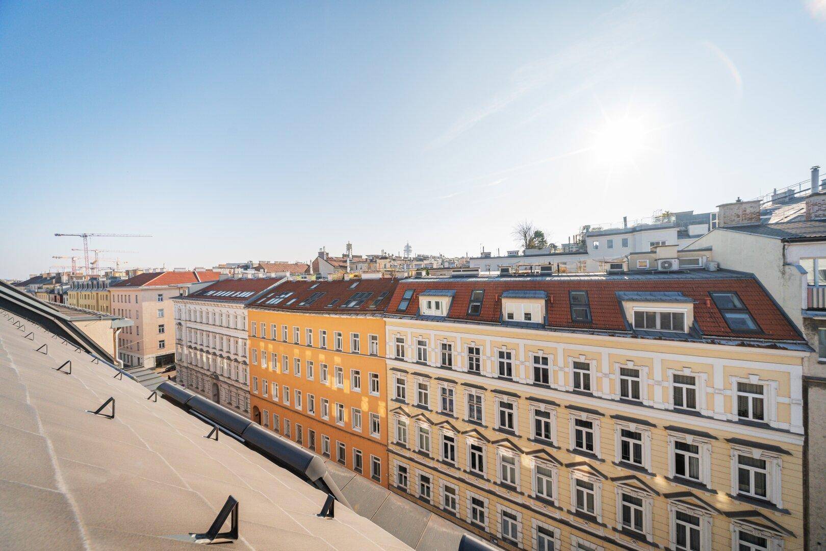 Weite Aussicht über die Dächer der Stadt an einem sonnigen Tag mit Blick auf die Umgebung.