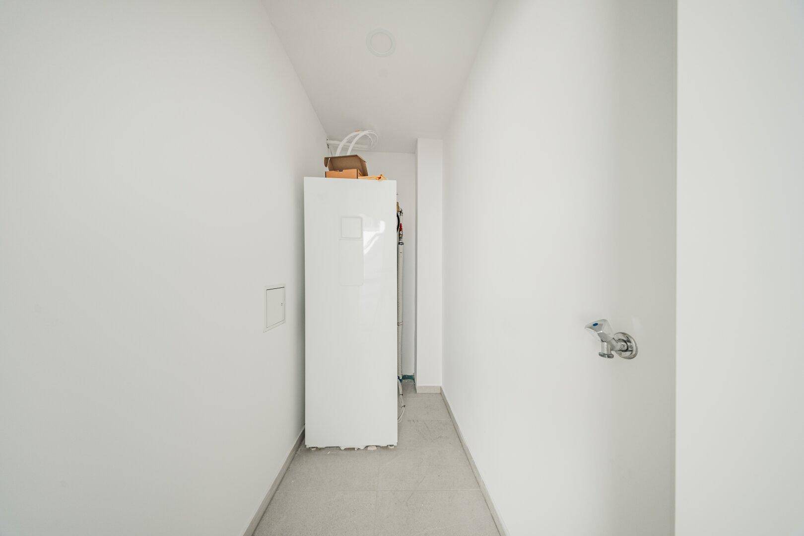 Praktischer Hauswirtschaftsraum mit Anschlüssen für Waschmaschine und Trockner.