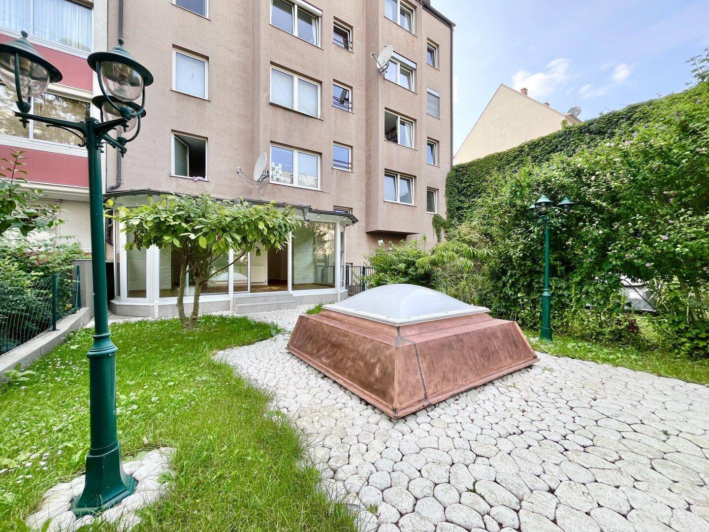 Außenansicht des Gebäudes mit einem gepflegten Garten und dekorativen Laternen.