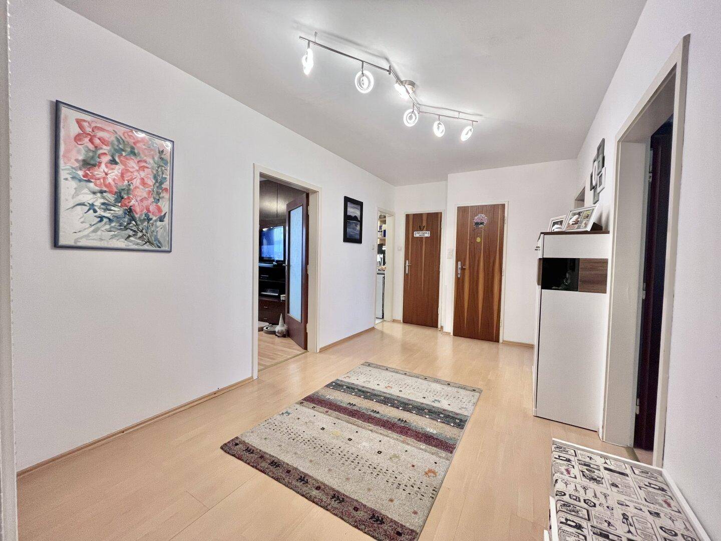 Eingangsbereich mit hellem Holzboden, Garderobe und Zugang zu weiteren Zimmern.