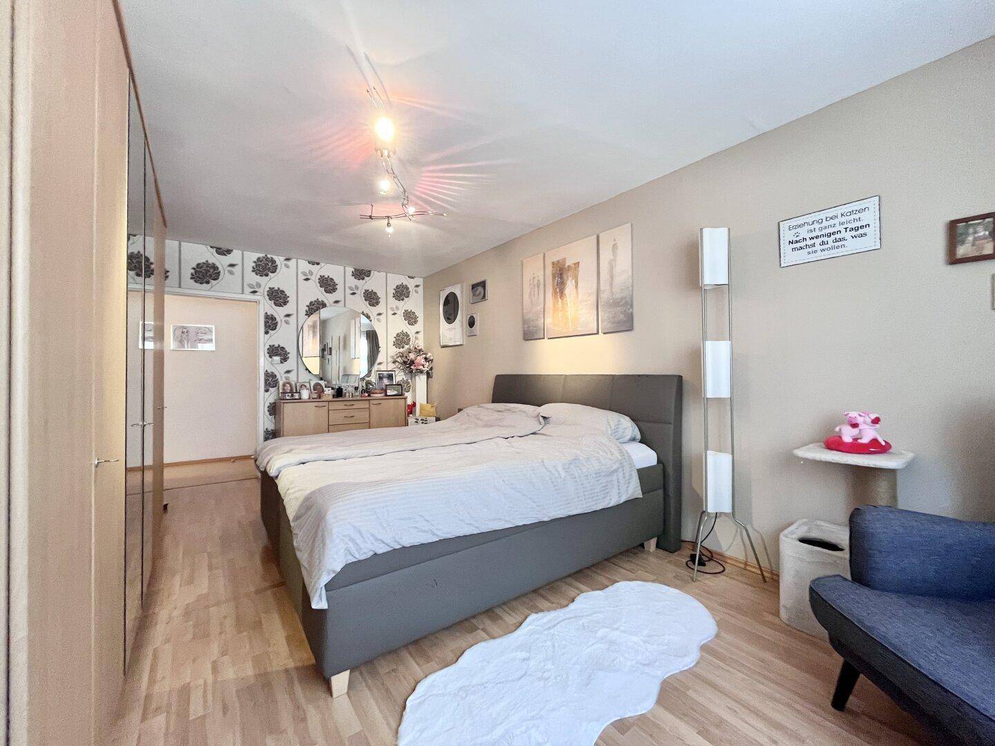 Gemütliches Schlafzimmer mit Doppelbett, Nachttischen und dekorativer Tapete.
