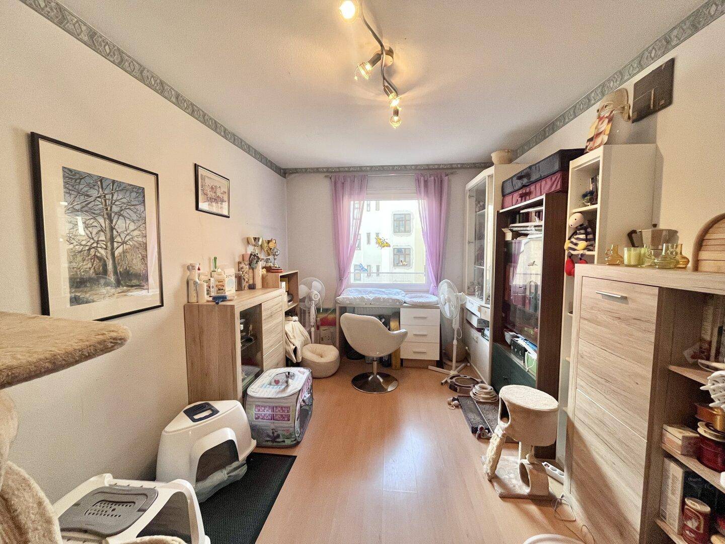 Kinderzimmer oder Gästezimmer mit Wickeltisch, Schränken und hellem Holzboden.
