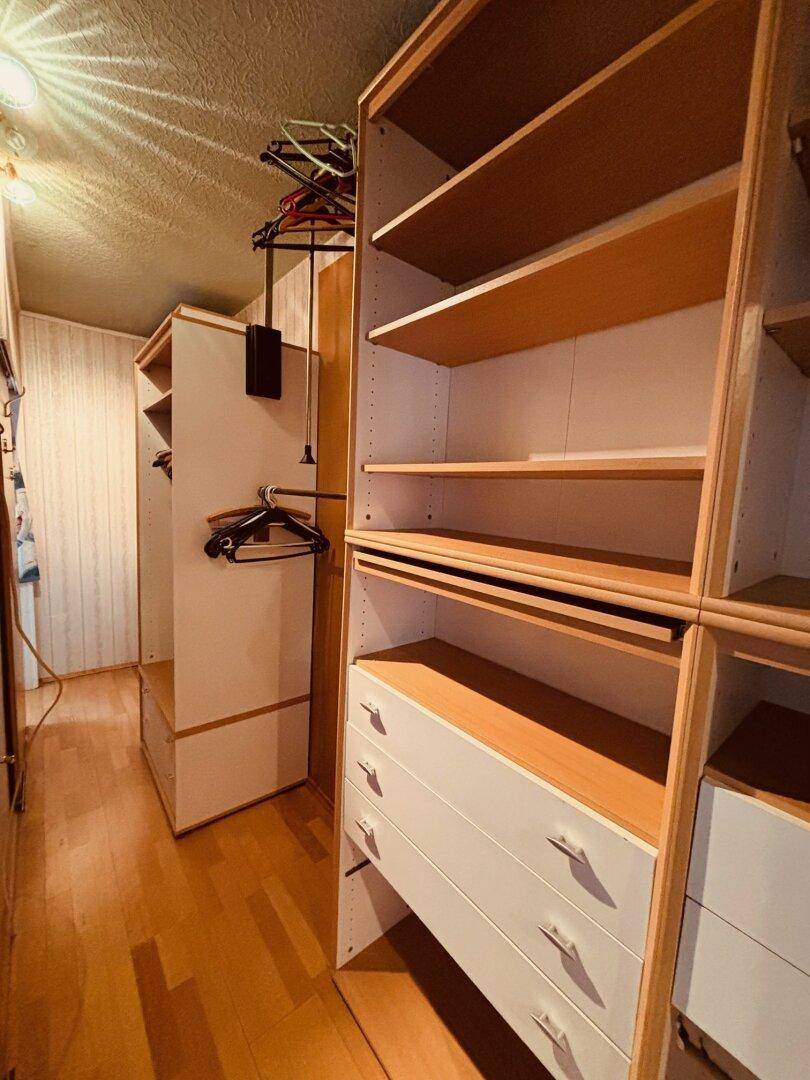 Begehbarer Kleiderschrank mit Regalen, Schubladen und Kleiderstangen für viel Stauraum.