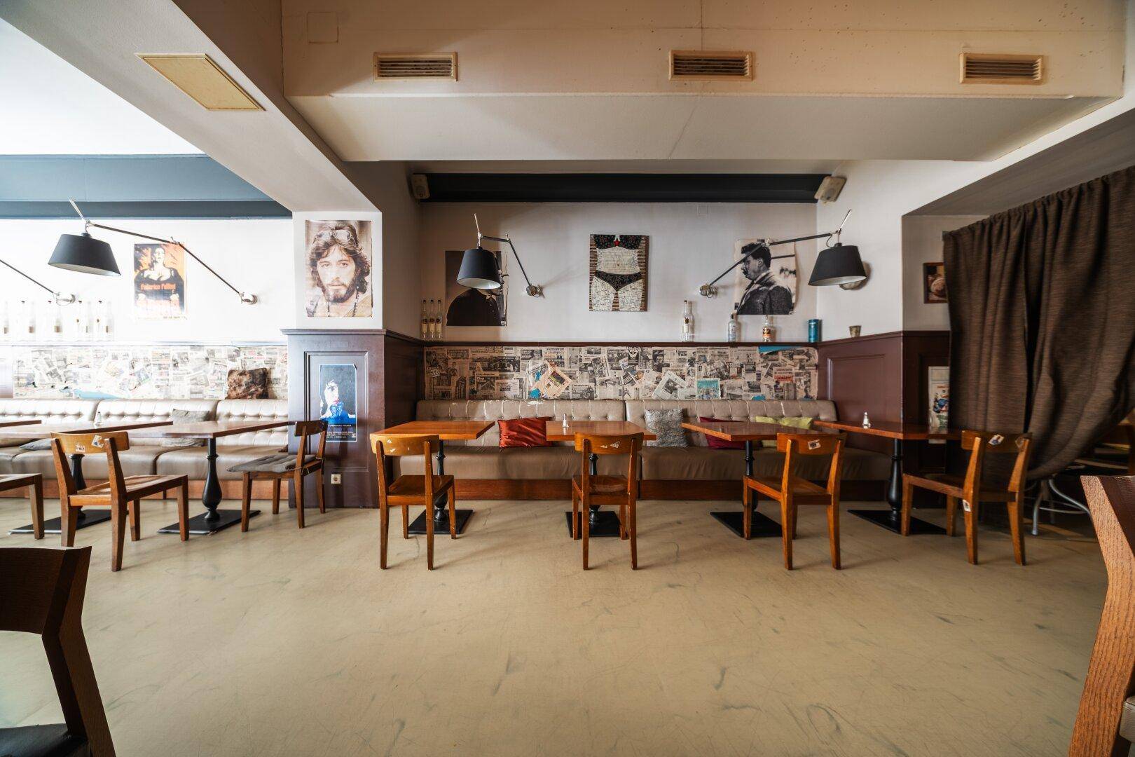 Gemütlicher Restaurantbereich mit gepolsterten Sitzbänken, Holztischen und Wanddekorationen.