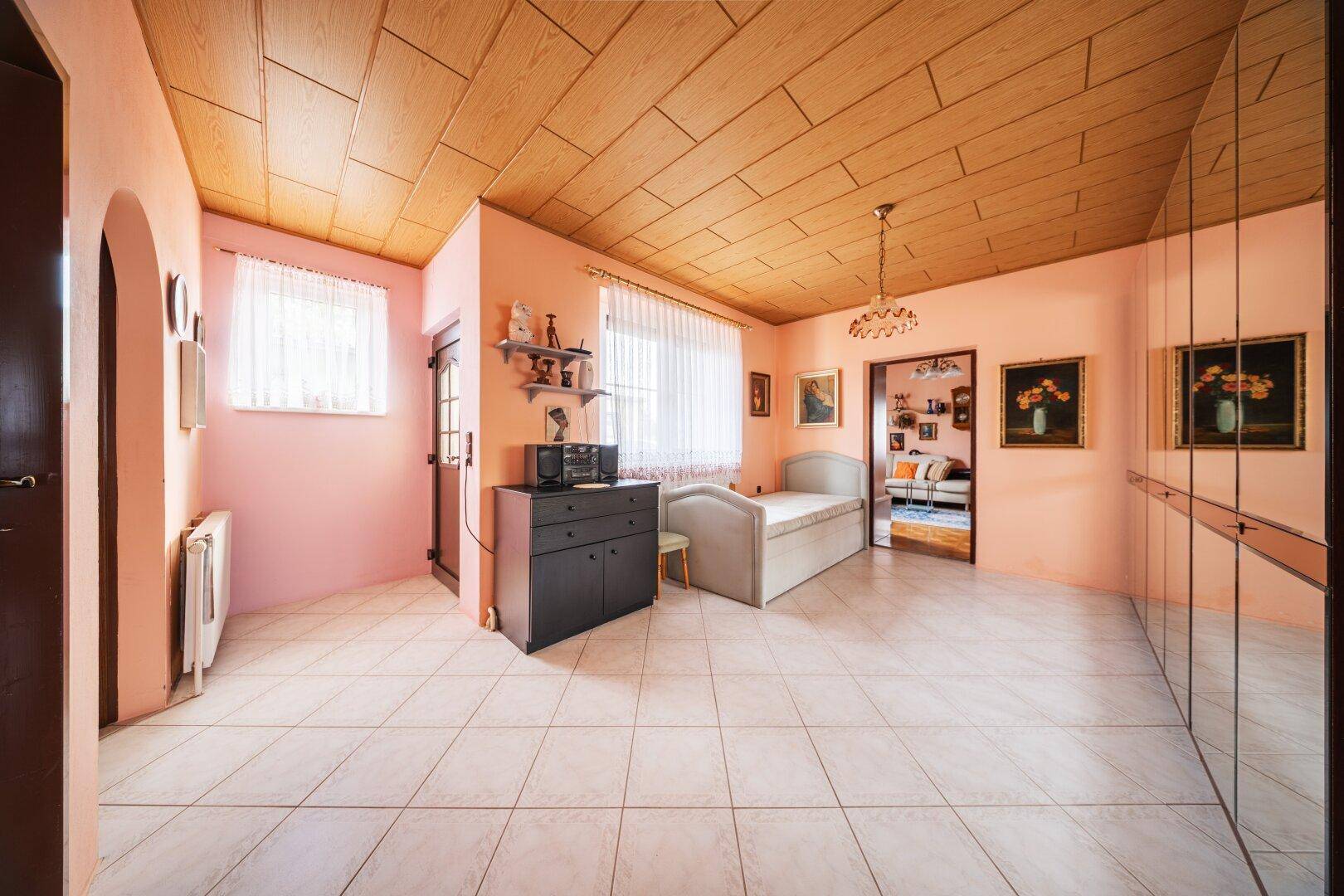 Geräumiges Zimmer mit Fliesenboden, Spiegelschränken und Einzelbett.