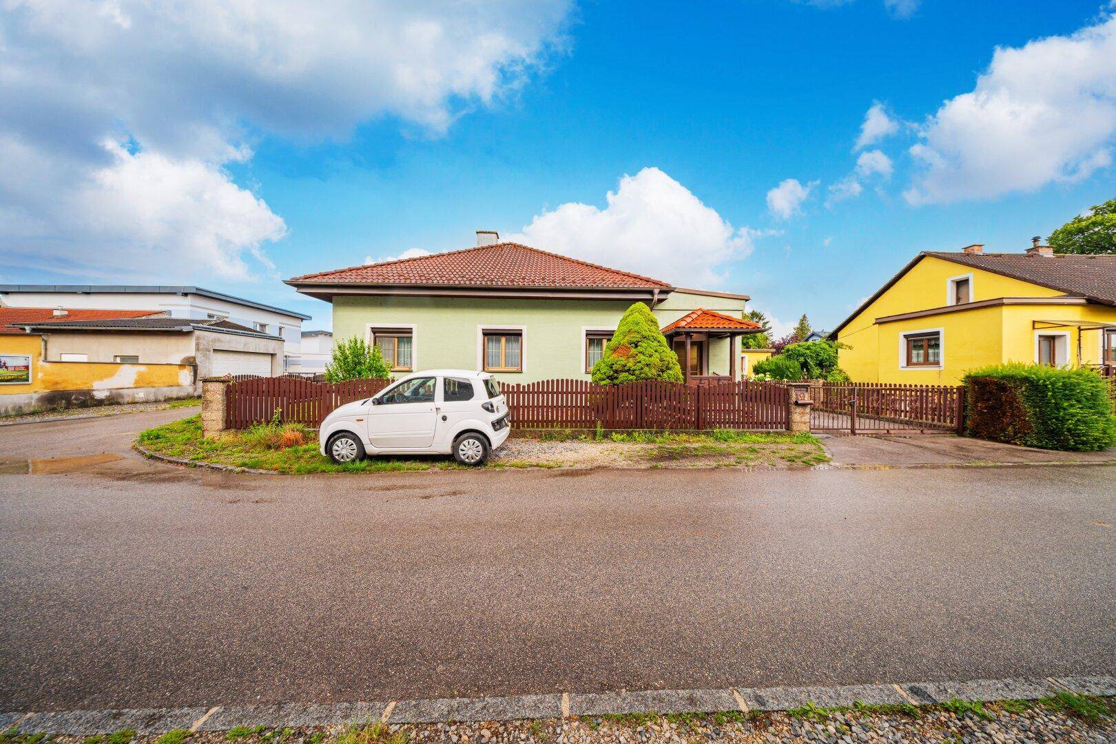 Vorderansicht des Einfamilienhauses von der Straße aus mit Vorgarten und Zaun.