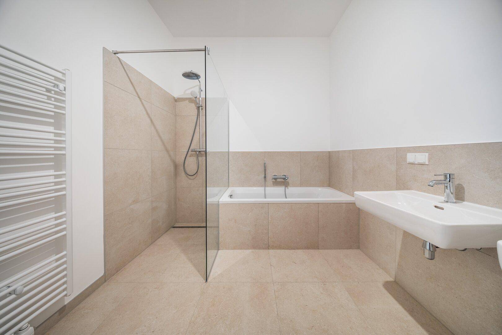 Helles Badezimmer mit beigen Fliesen, Einzelwaschbecken, Badewanne und begehbarer Dusche.
