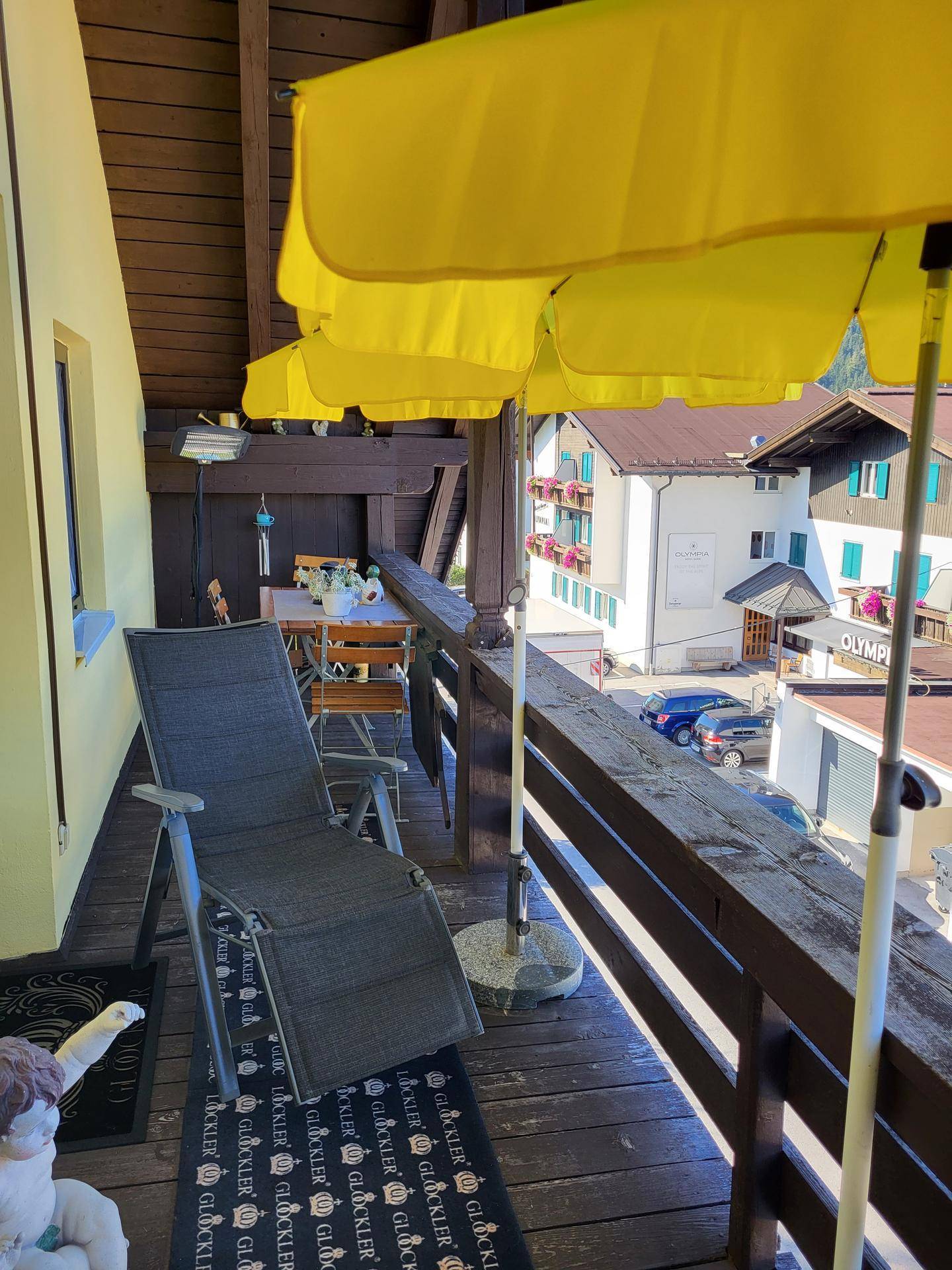 Geräumiger Balkon mit Sonnenliege und Sonnenschirm, ideal zum Entspannen im Freien.
