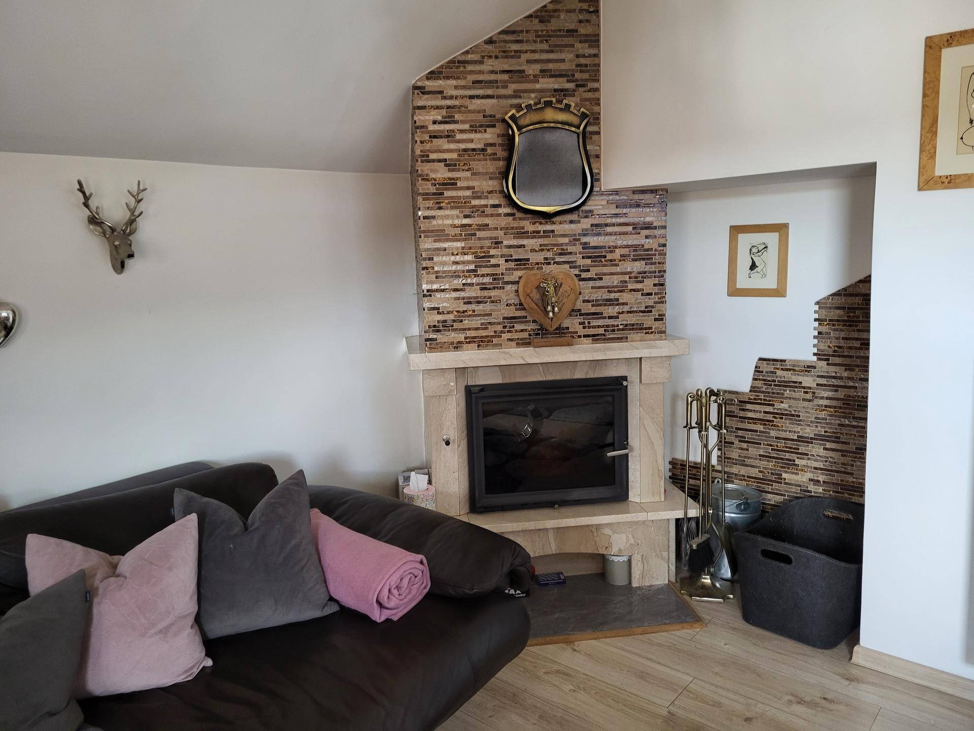 Gemütliches Wohnzimmer mit Kamin, bequemer Couch und rustikalen Dekorationen.