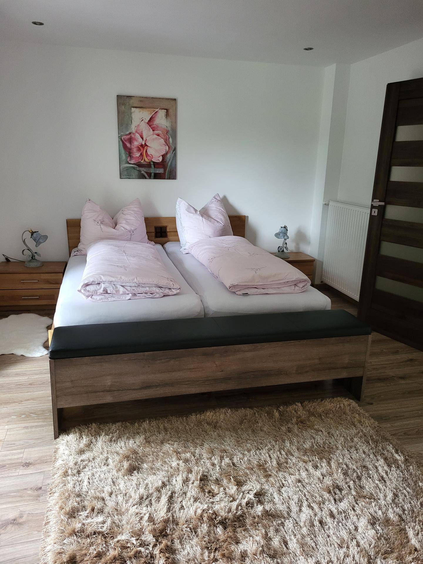 Gemütliches Schlafzimmer mit Doppelbett, Holzboden und moderner Einrichtung.