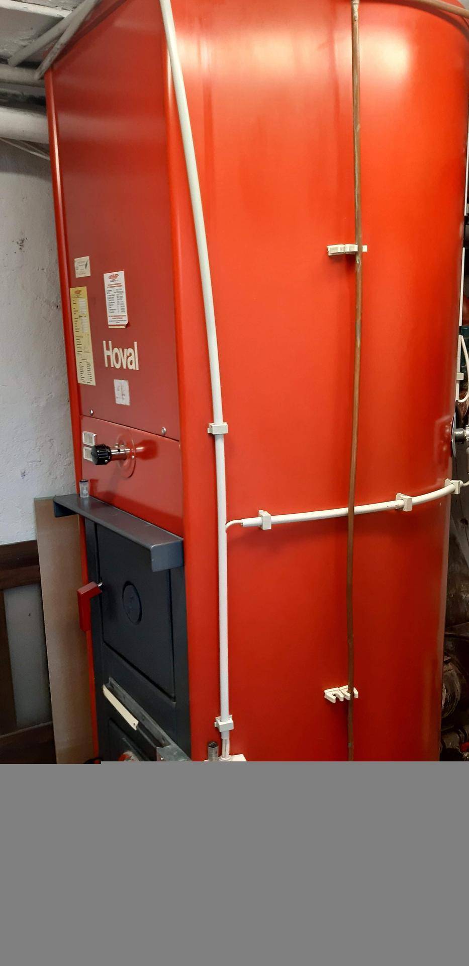 Rote Hoval Heizungsanlage mit Rohren in einem Technik- oder Heizraum.
