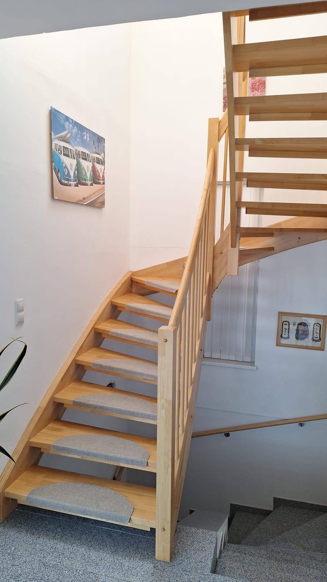 Helle Holztreppe mit offenen Stufen, verbindet die verschiedenen Wohnebenen.
