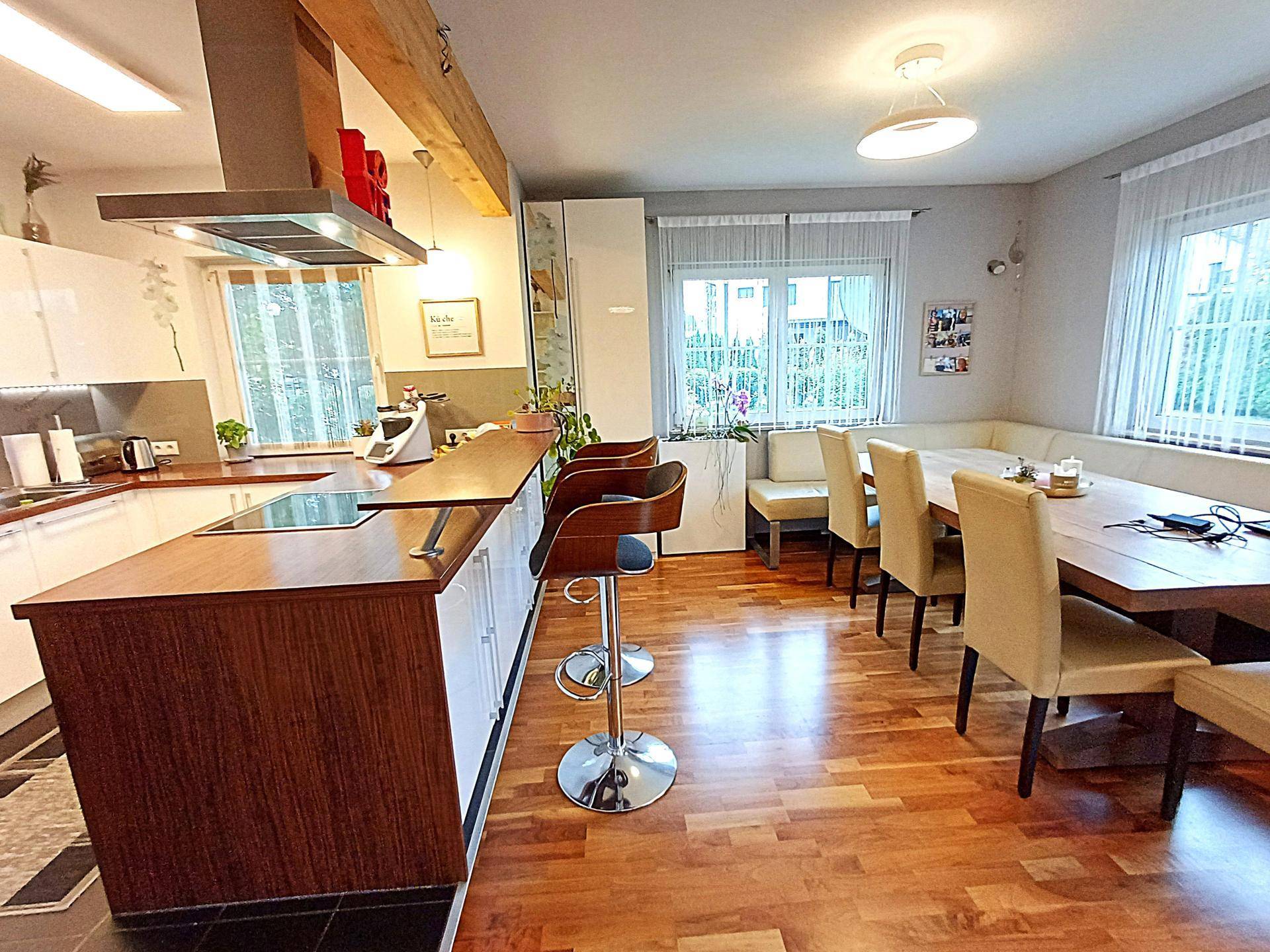 Moderne Küche mit Holztheke, integriertem Essbereich und Holzboden.
