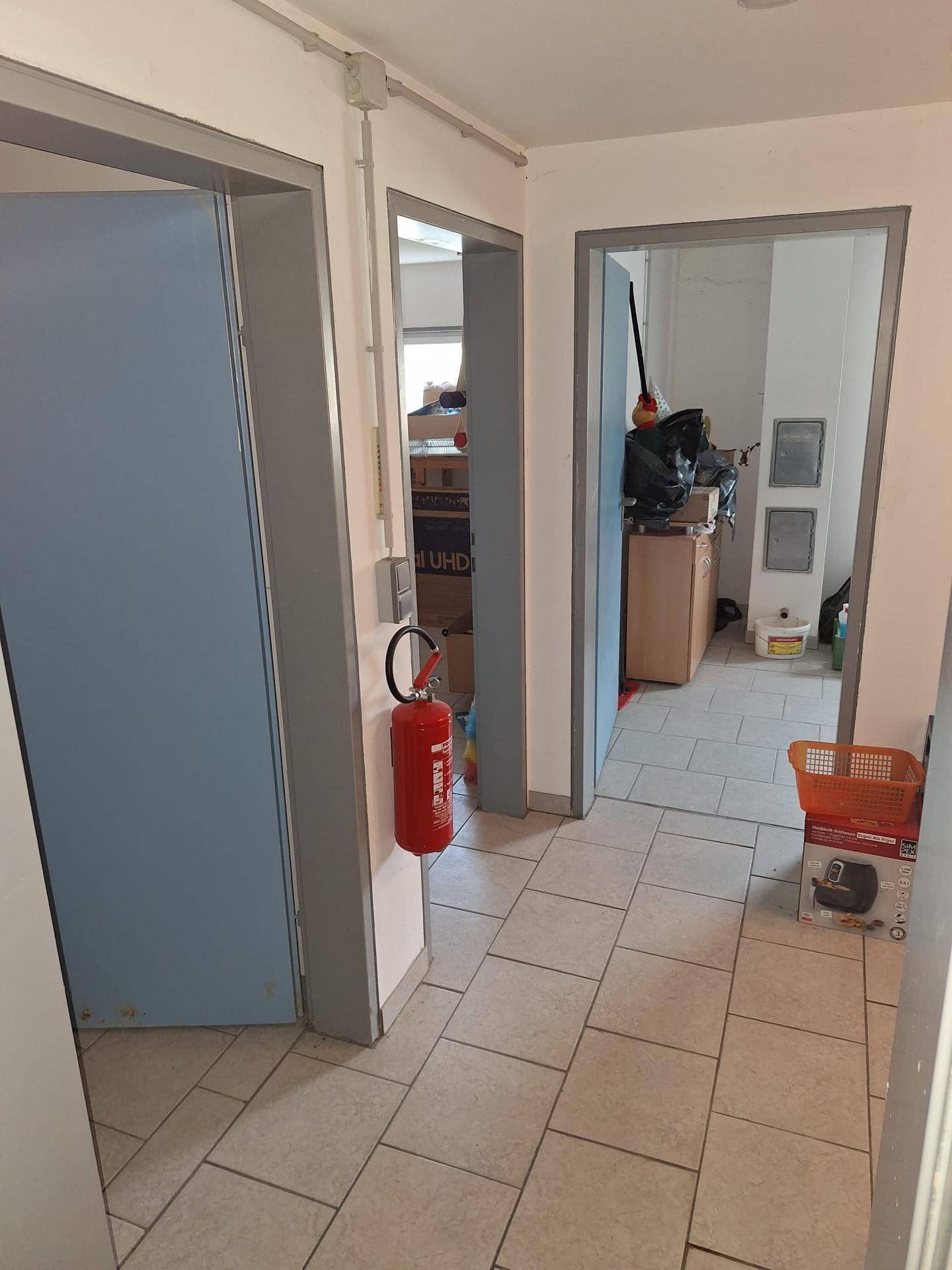 Flur im Untergeschoss mit Fliesenboden und Zugang zu mehreren Räumen.