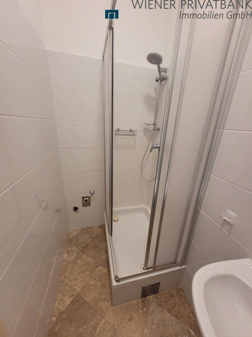 Kompaktes Badezimmer mit Duschkabine und Wandfliesen.